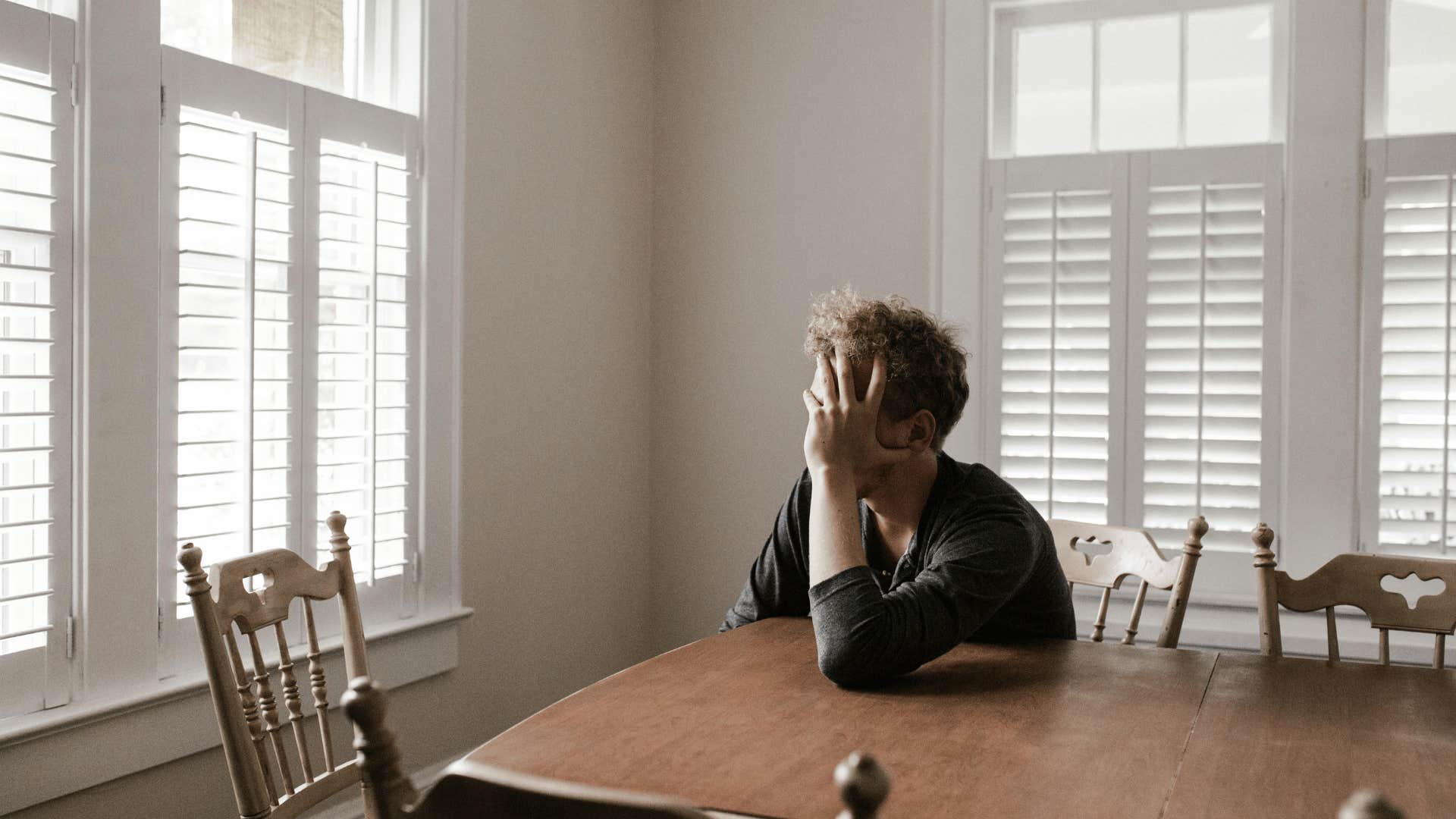 upset man sitting at table