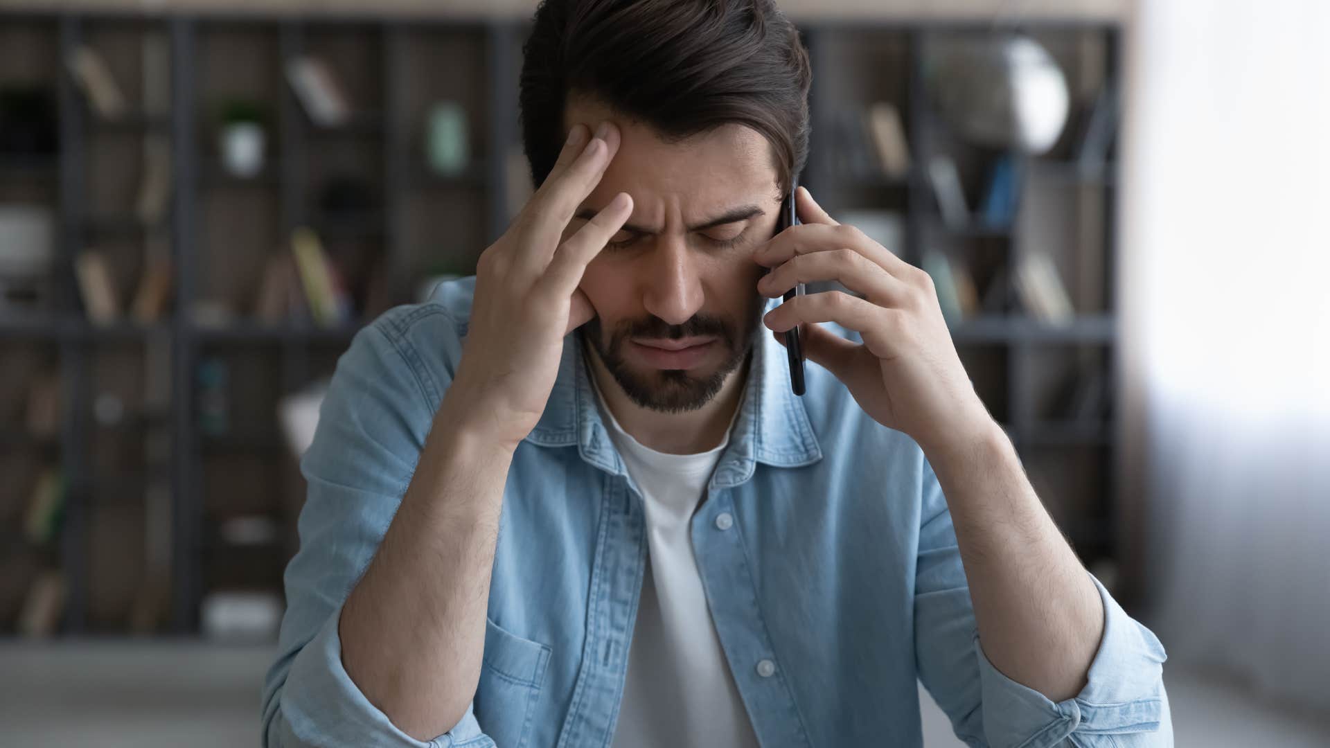 Man looking stressed talking on the phone.