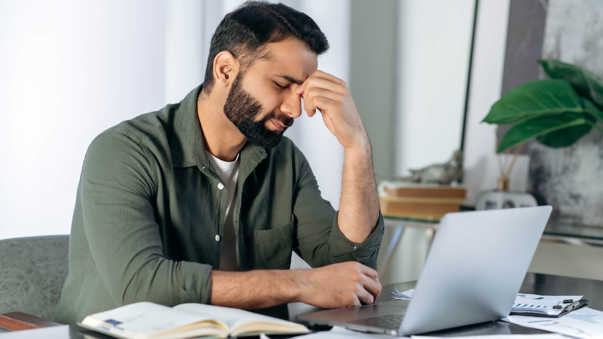 Man looking stressed working on his laptop.