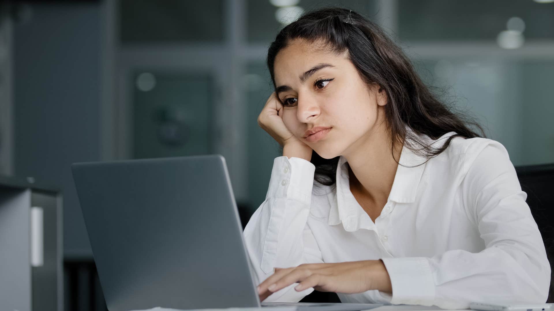 Professional woman looking annoyed on her laptop.