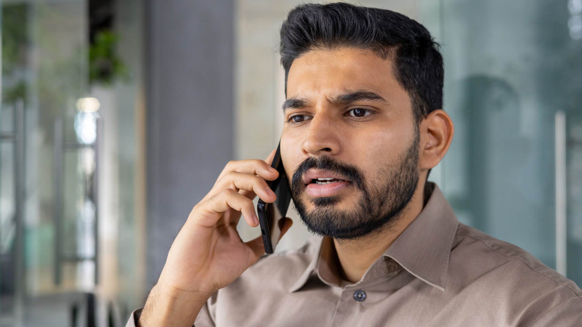 Professional man talking on the phone looking upset.