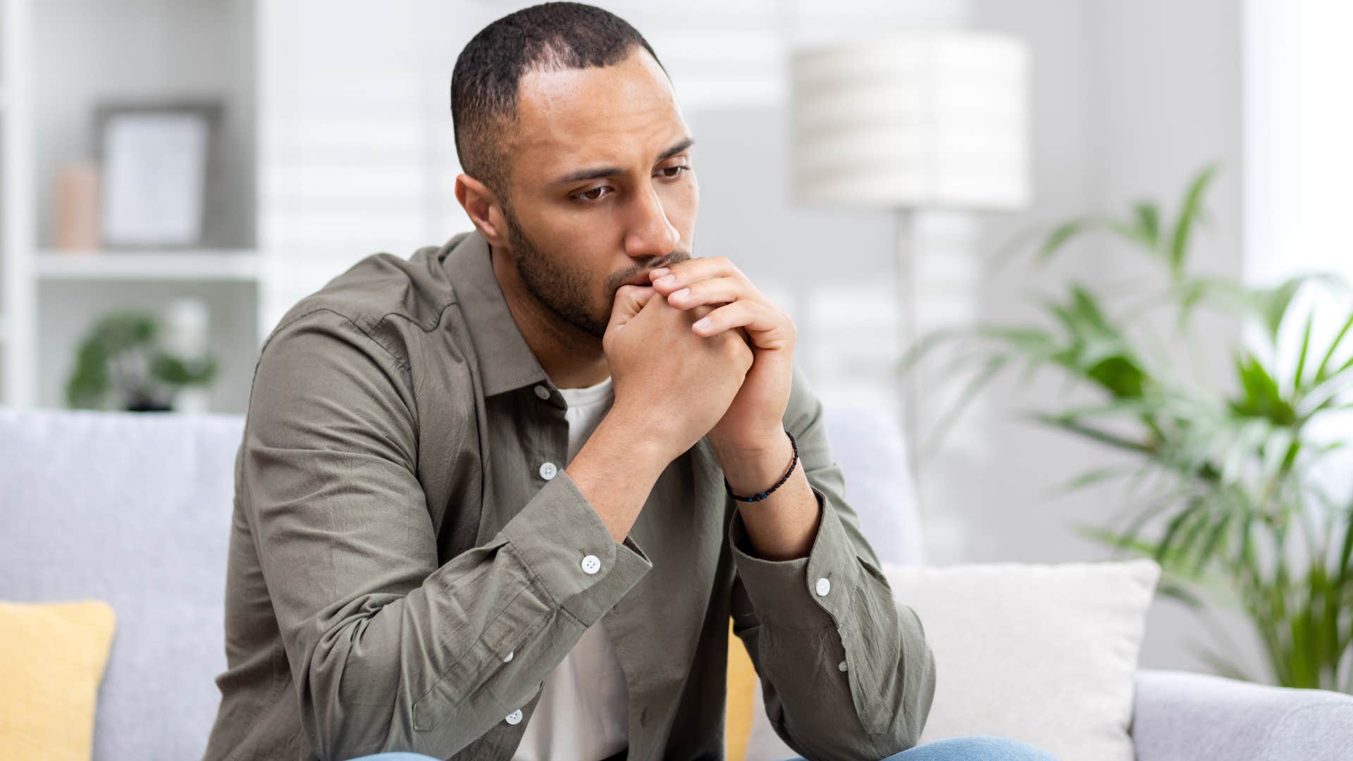 Man looking upset with his head in his hands.