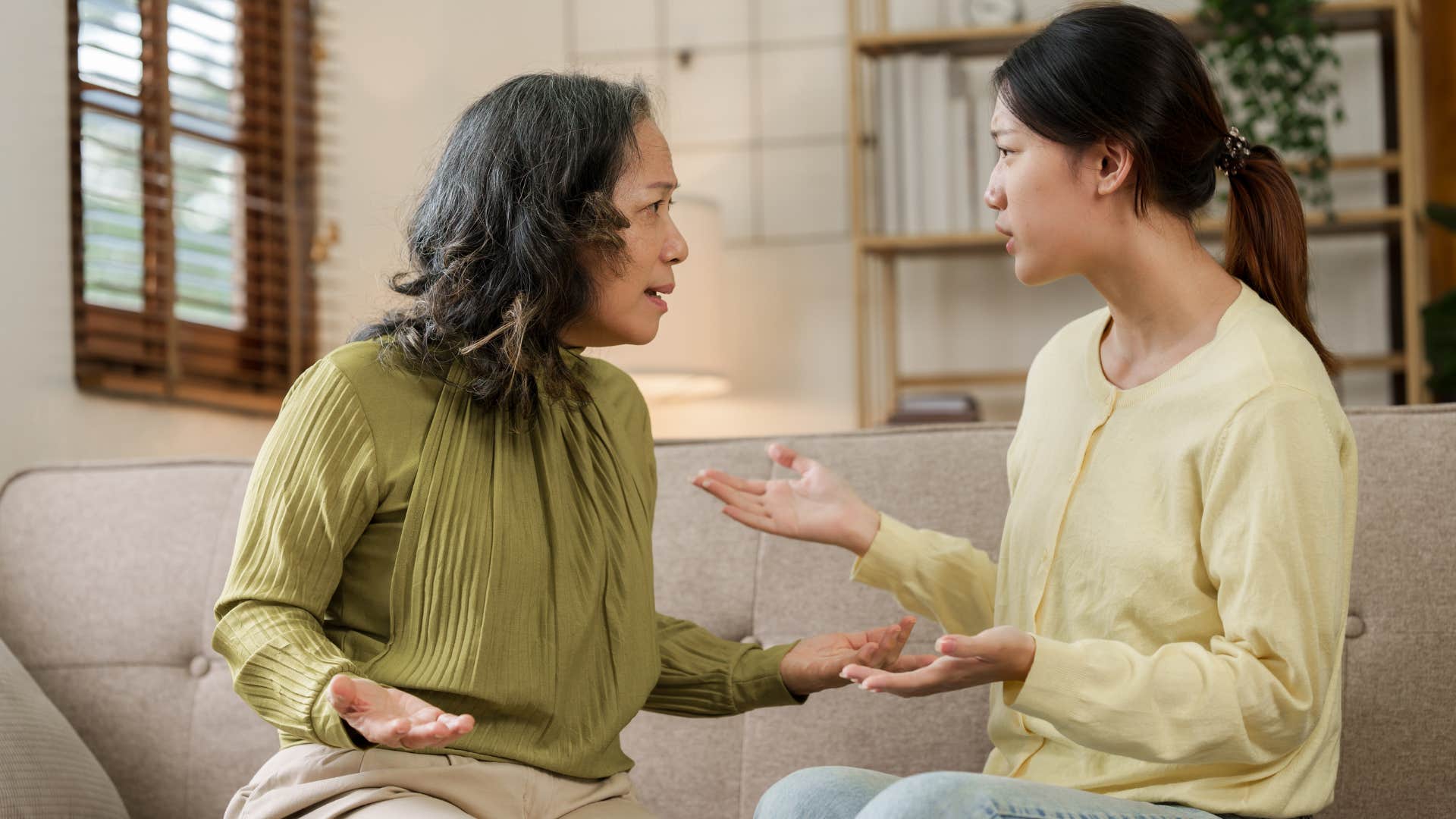 Adult daughter arguing with her mother on the couch.