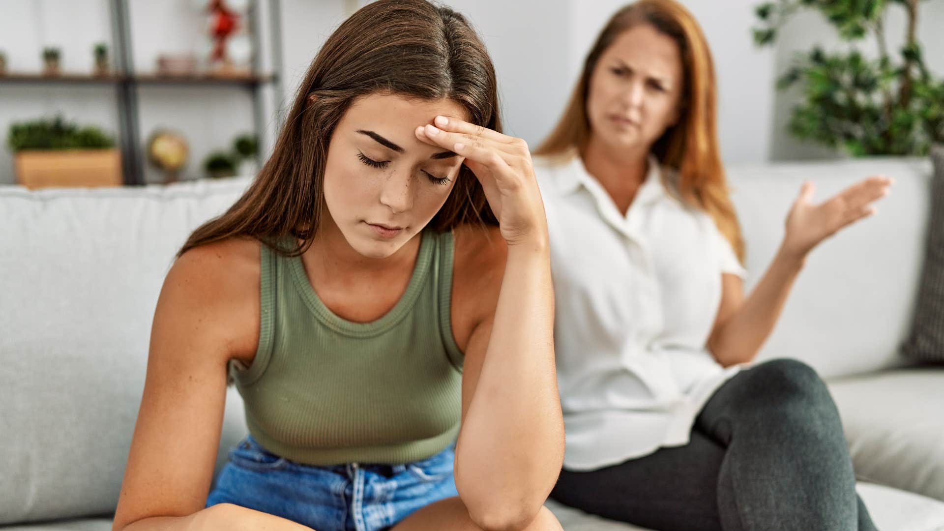 Woman looking annoyed while her mom argues with her