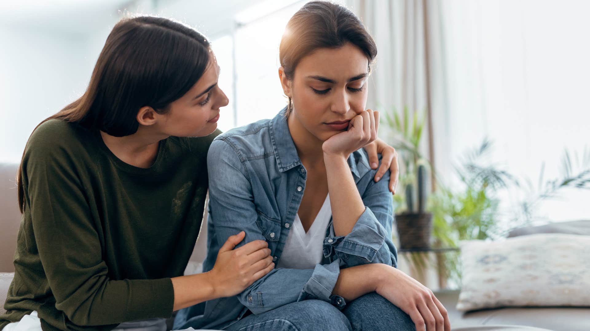 Woman comforting her upset partner on the couch