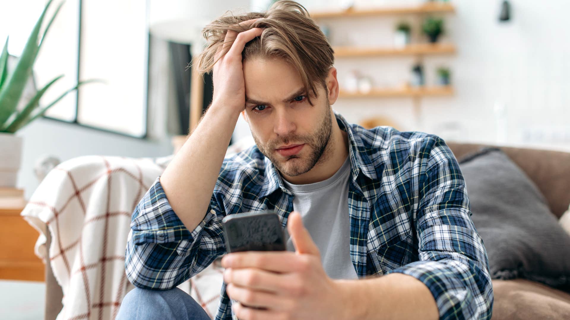 Man looking stressed staring at his phone