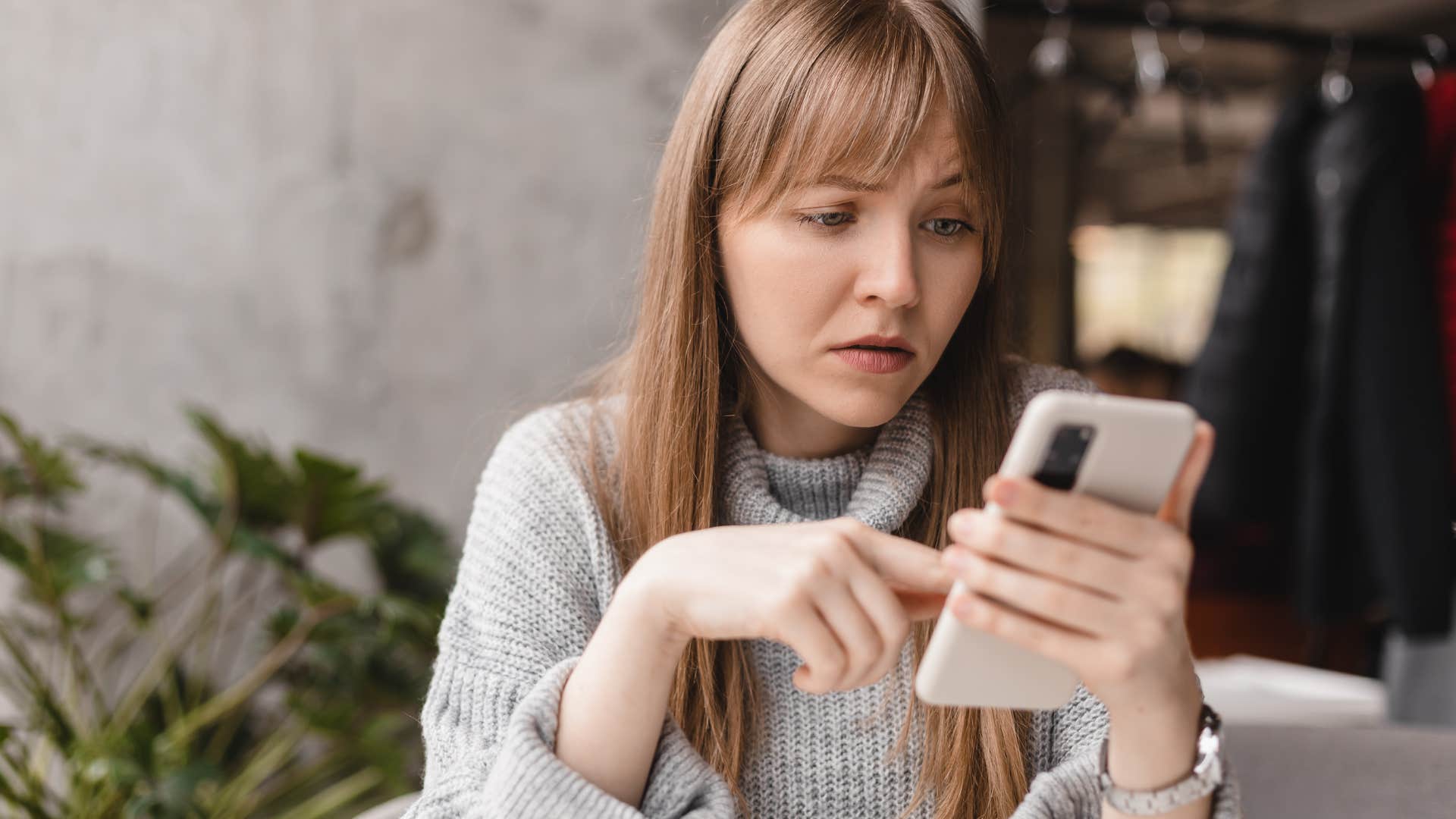 Woman looking confused staring at her phone