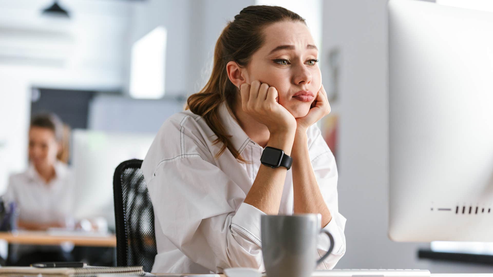 Woman looking bored sitting in front of her laptop