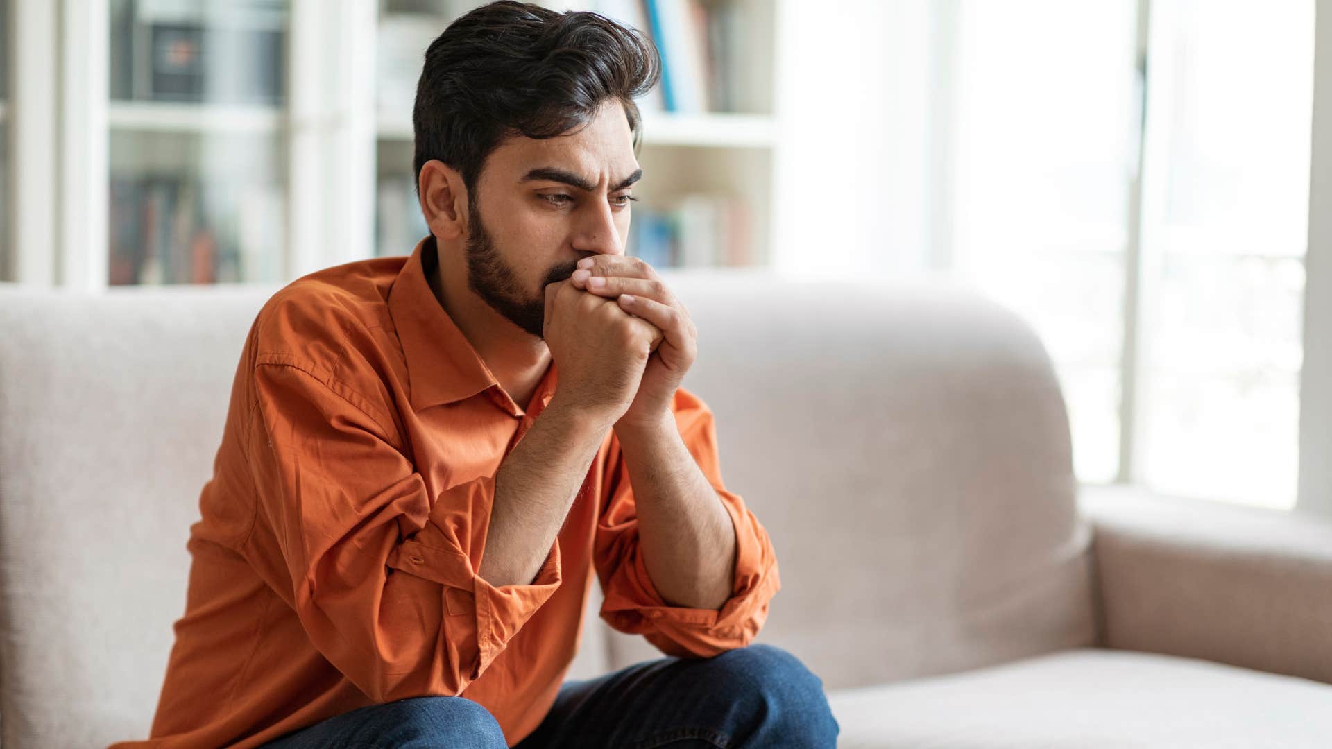 Man looking upset sitting on the couch