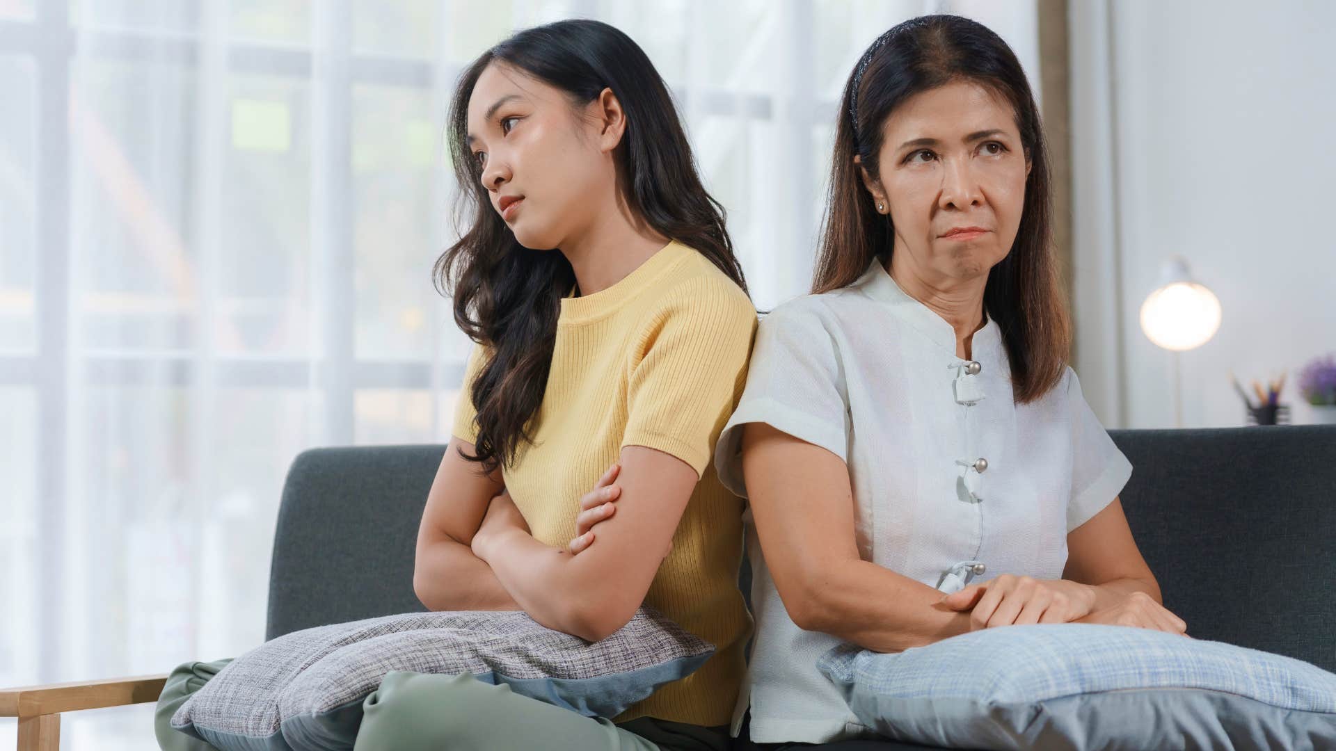 Mother and daughter sitting on the couch not facing each other