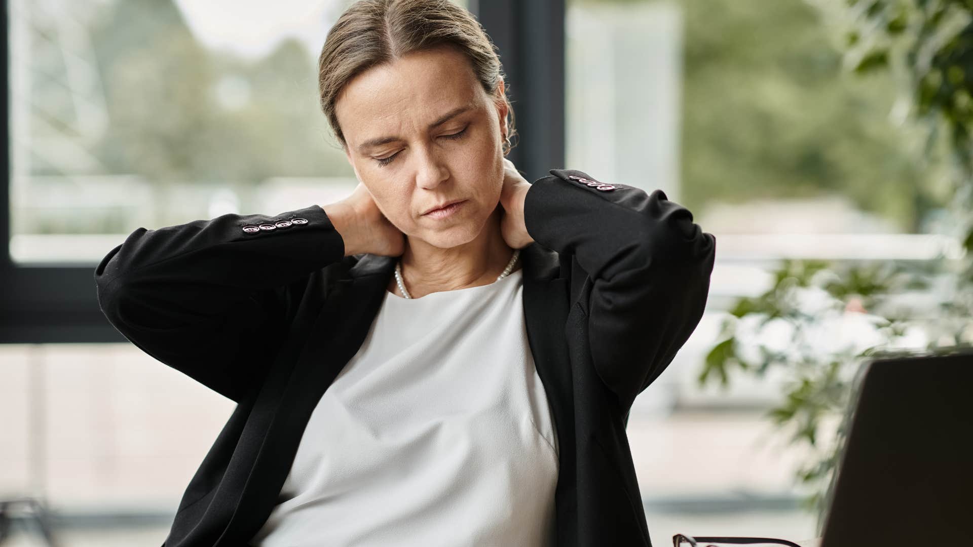 Woman adjusting her posture at her work desk