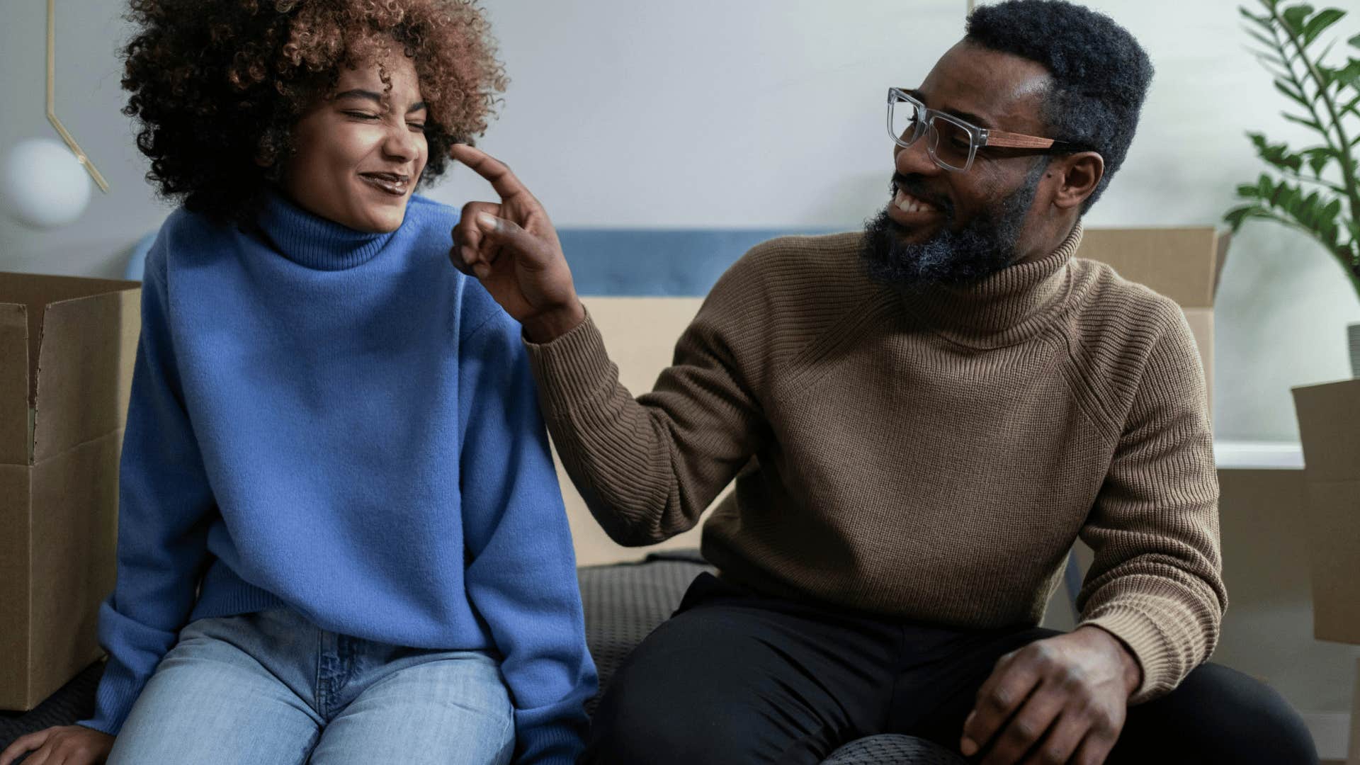 man touching nose of girl next to him