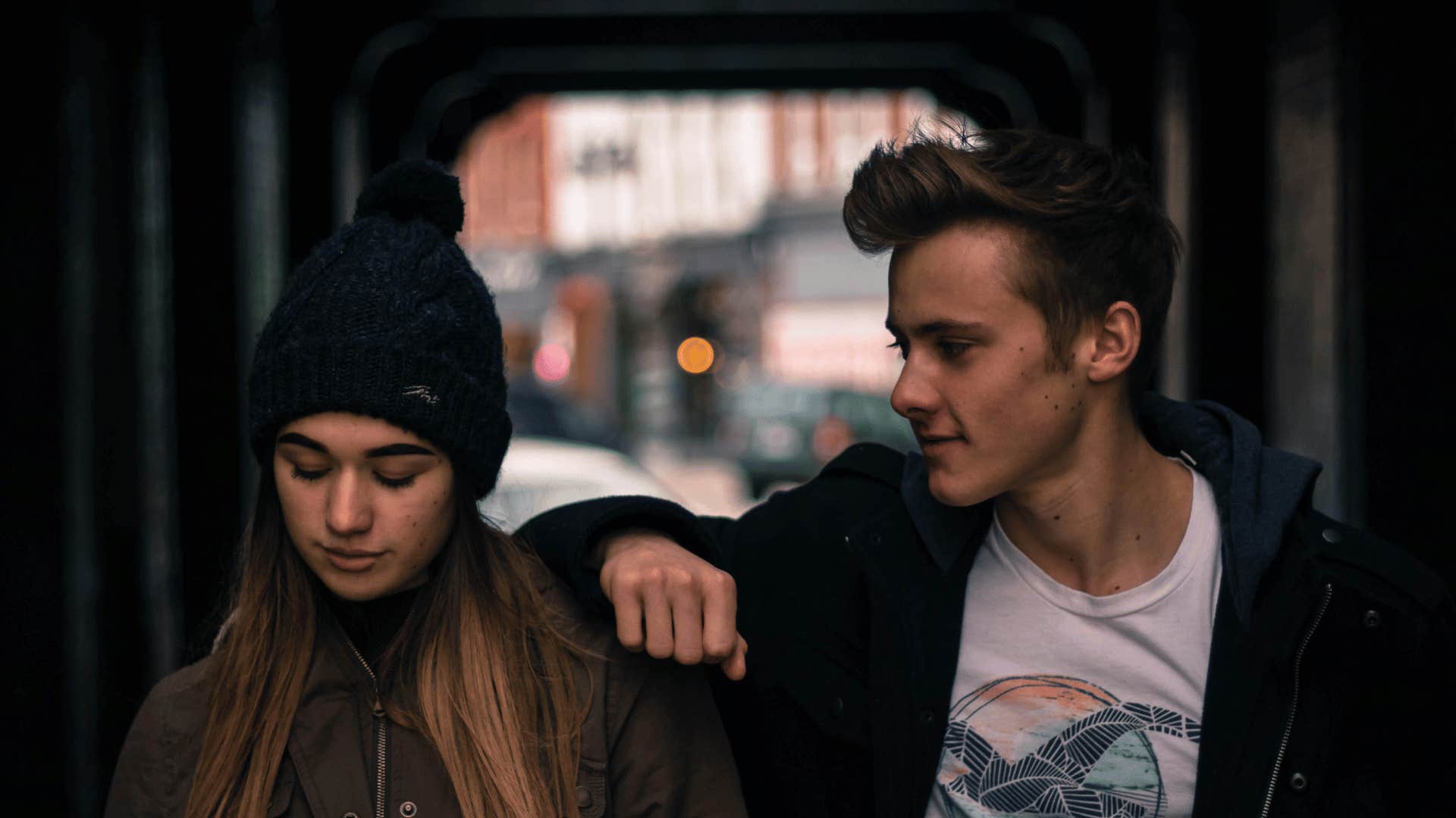 man looking at woman with his arm on her shoulder