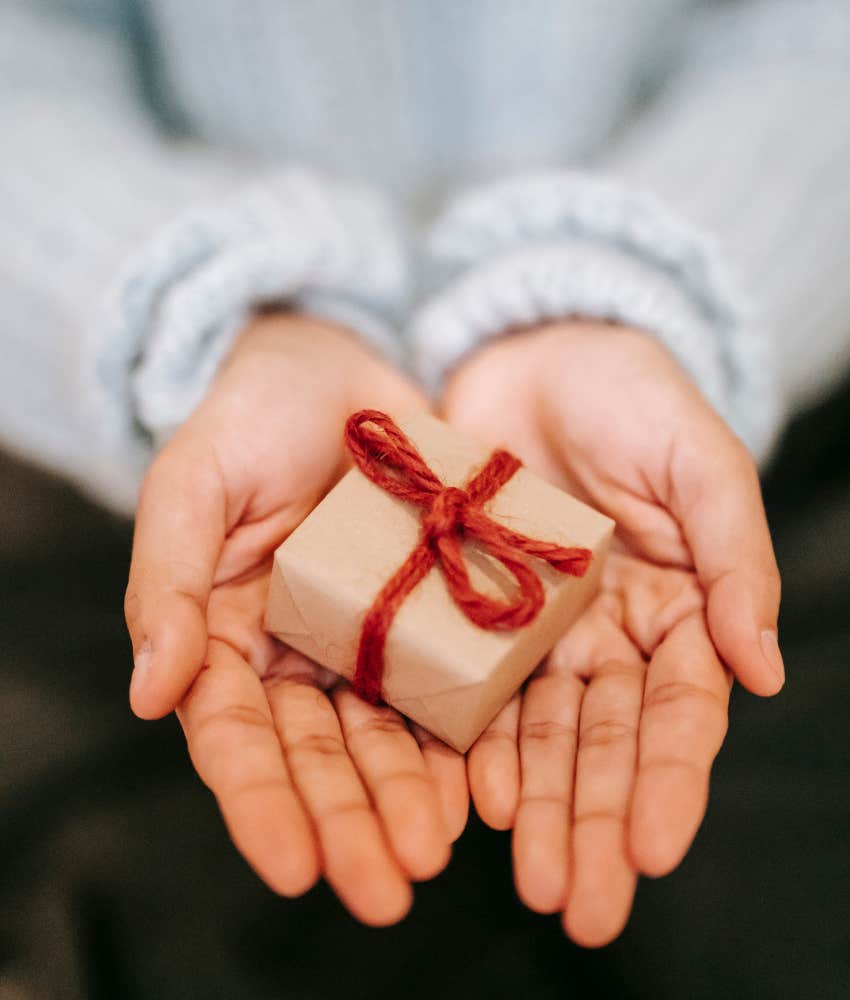 woman holding a tiny Christmas present