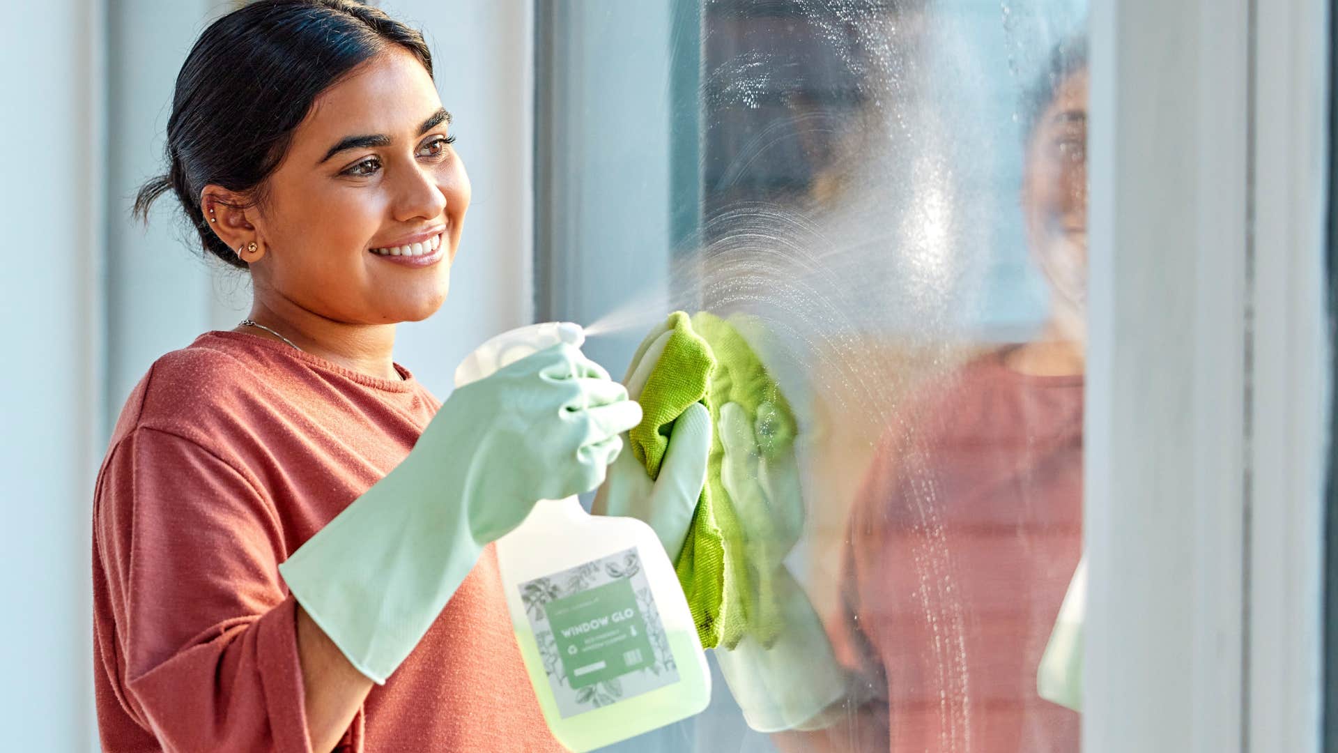 Woman smiling and cleaning her window