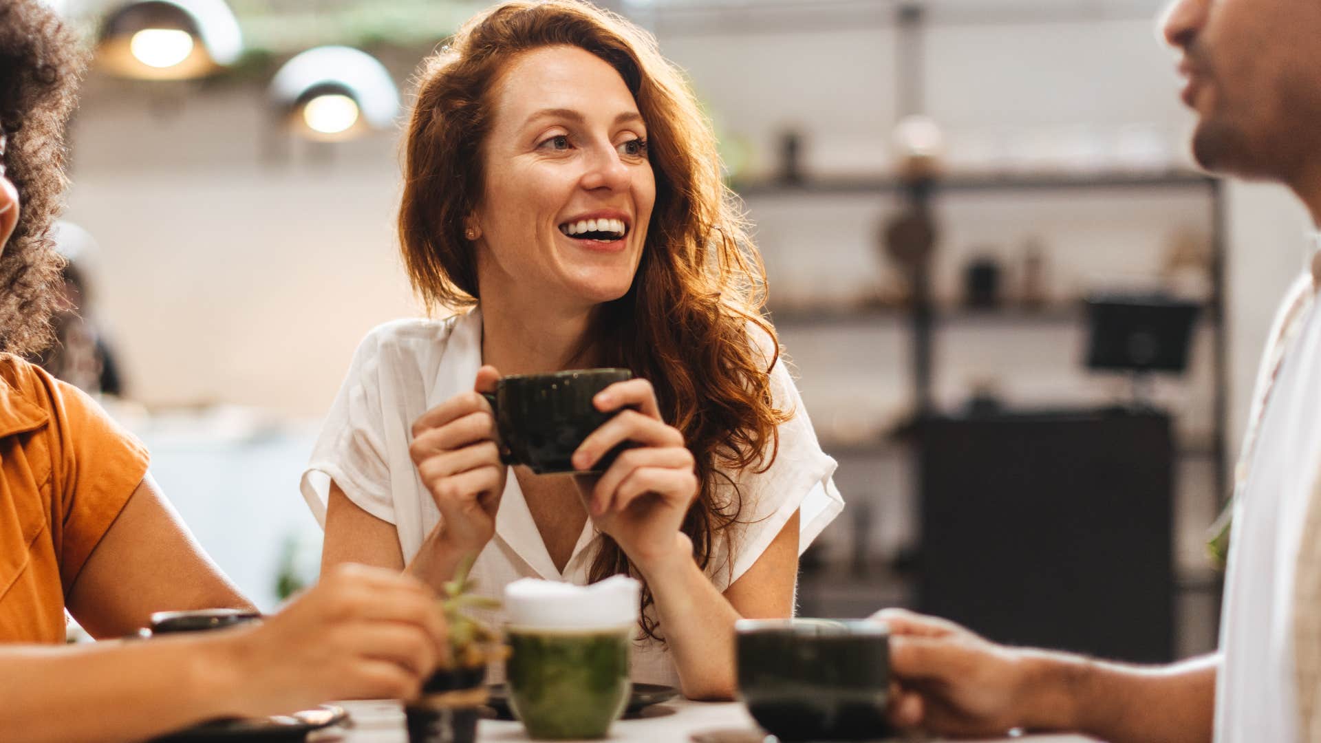 Friends smiling and drinking coffee together