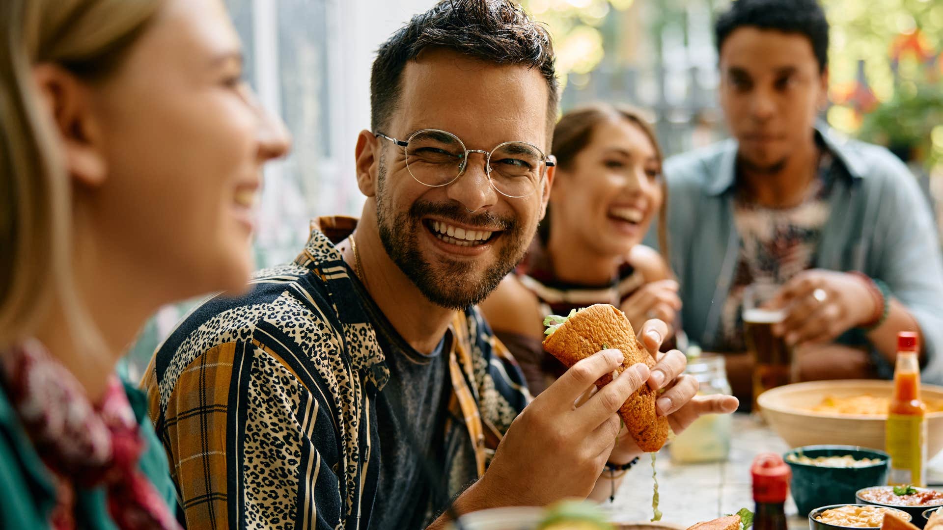 Man smiling and eating a burger