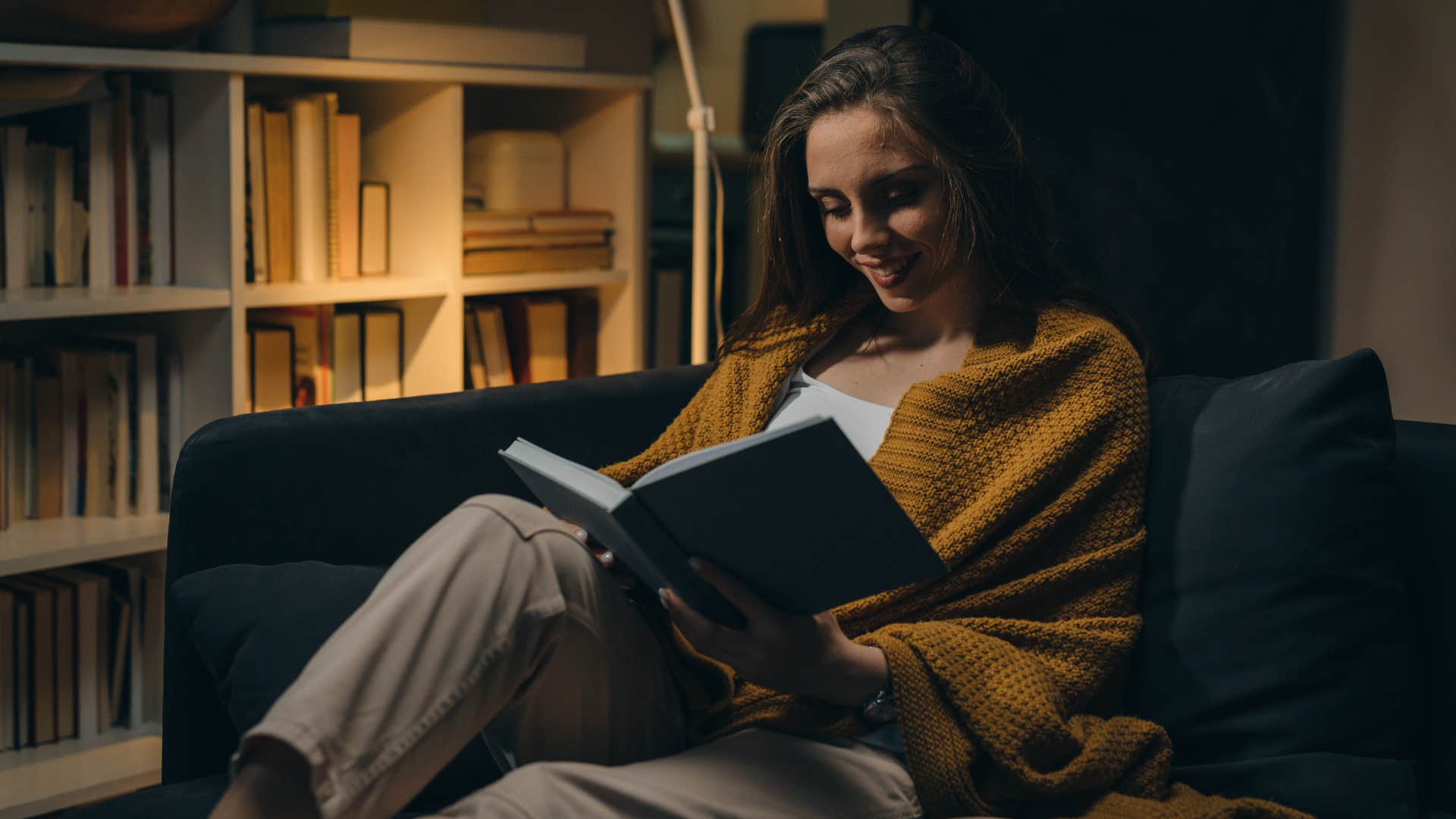 Woman reading a book in a dark room