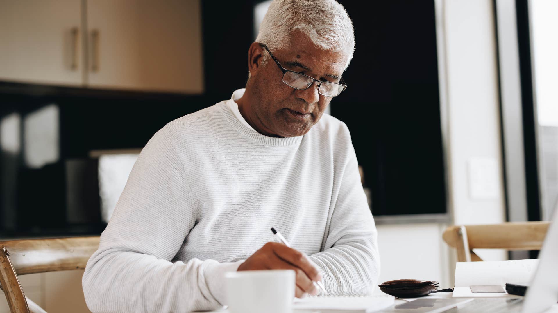 Older man writing in a notebook