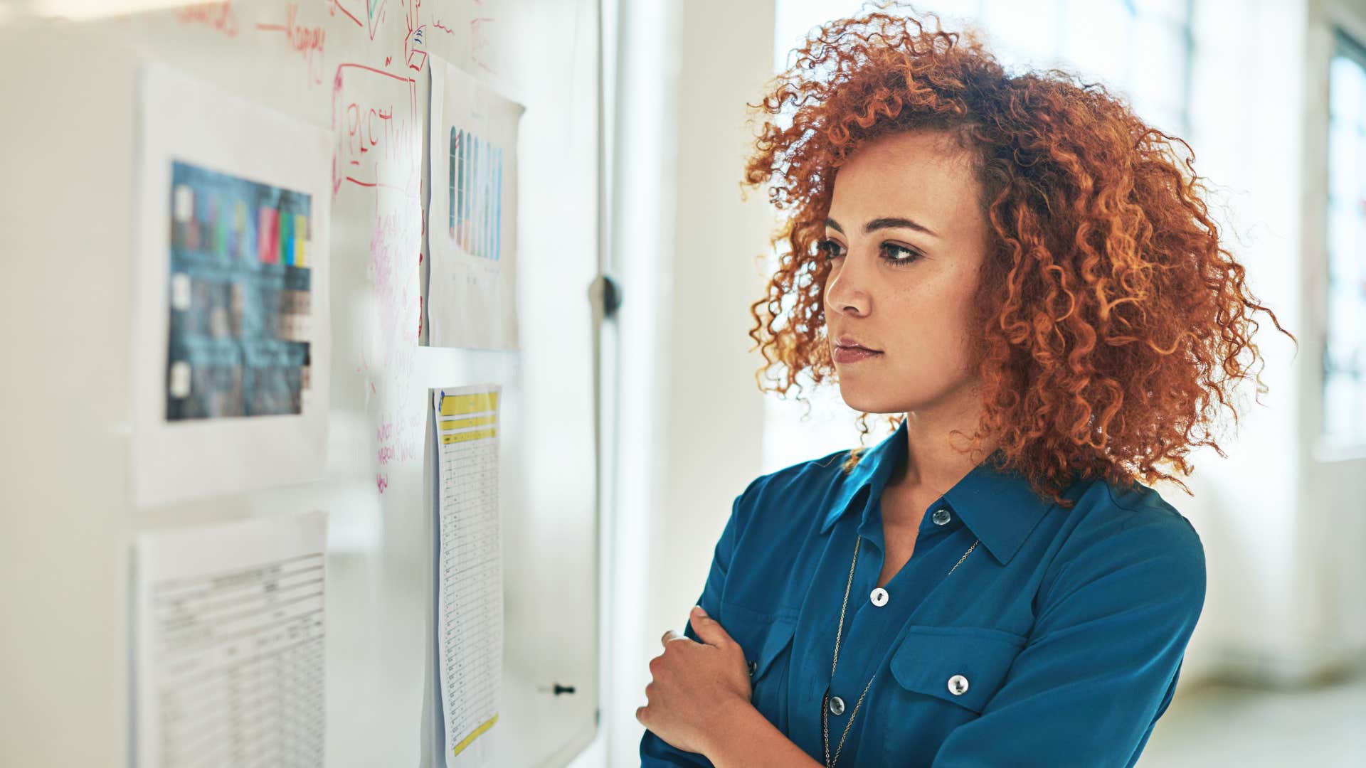 Woman looking at a vision board on the wall