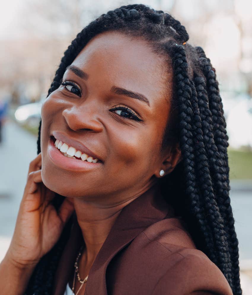 Smiling woman touches her face as she flirts