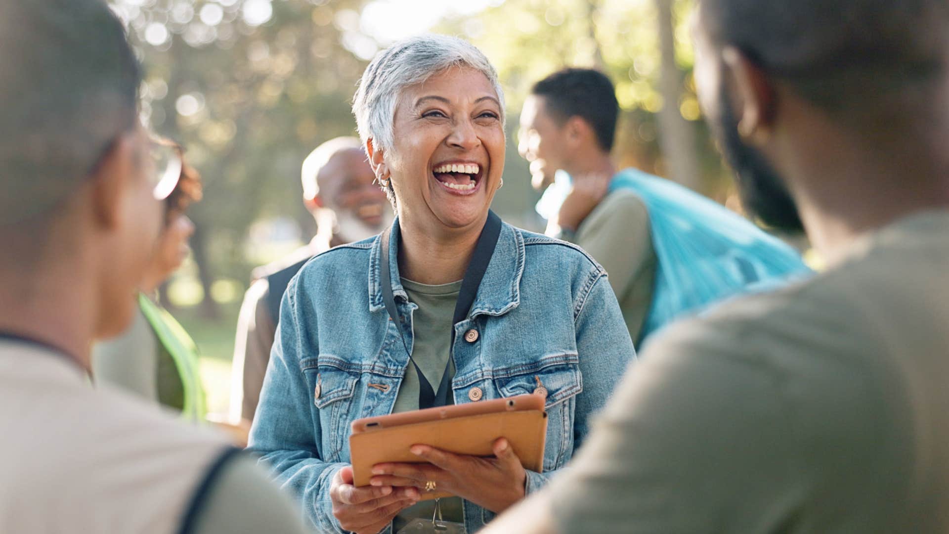 Woman smiling brightly while talking to two men