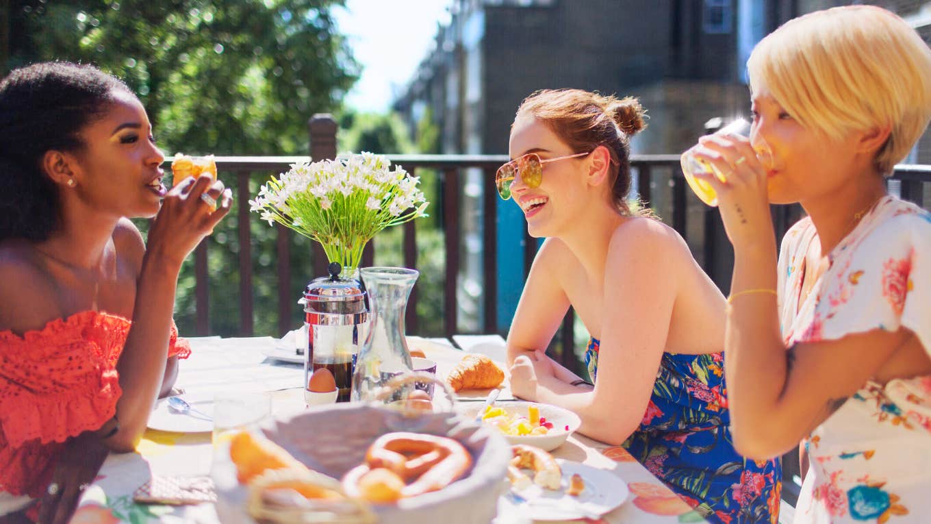 Woman gossiping with her girlfriends over brunch.