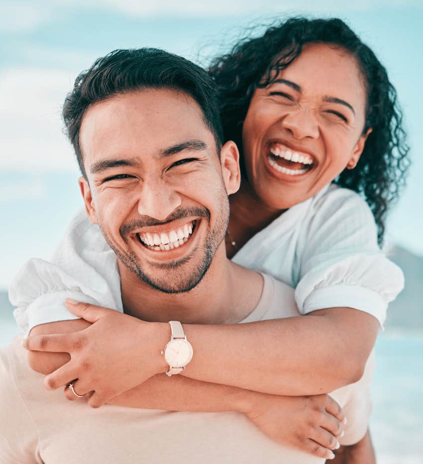 Happy couple hug on beach get away to stay together