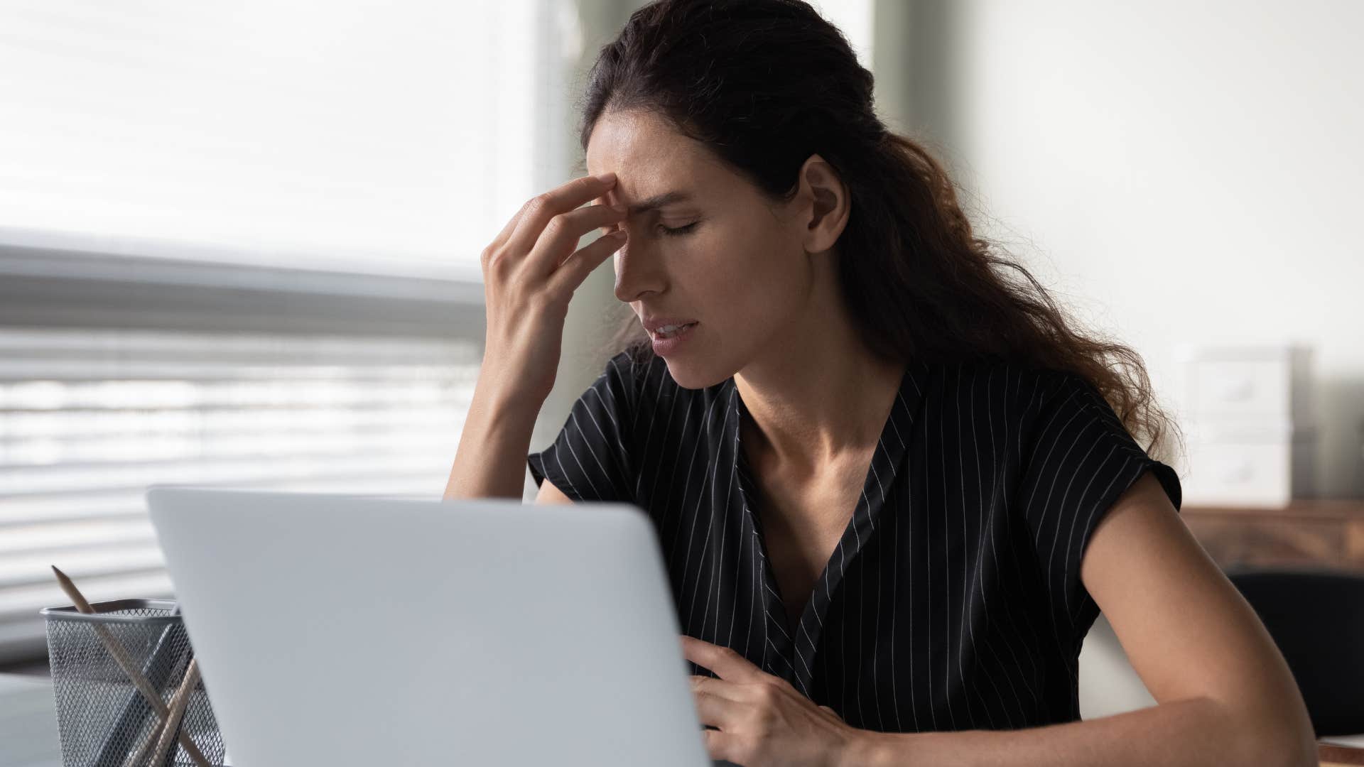 Woman looking stressed holding her head in her hands.