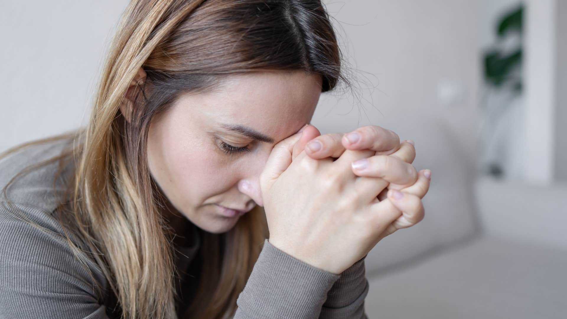 Woman holding her head in her hands.