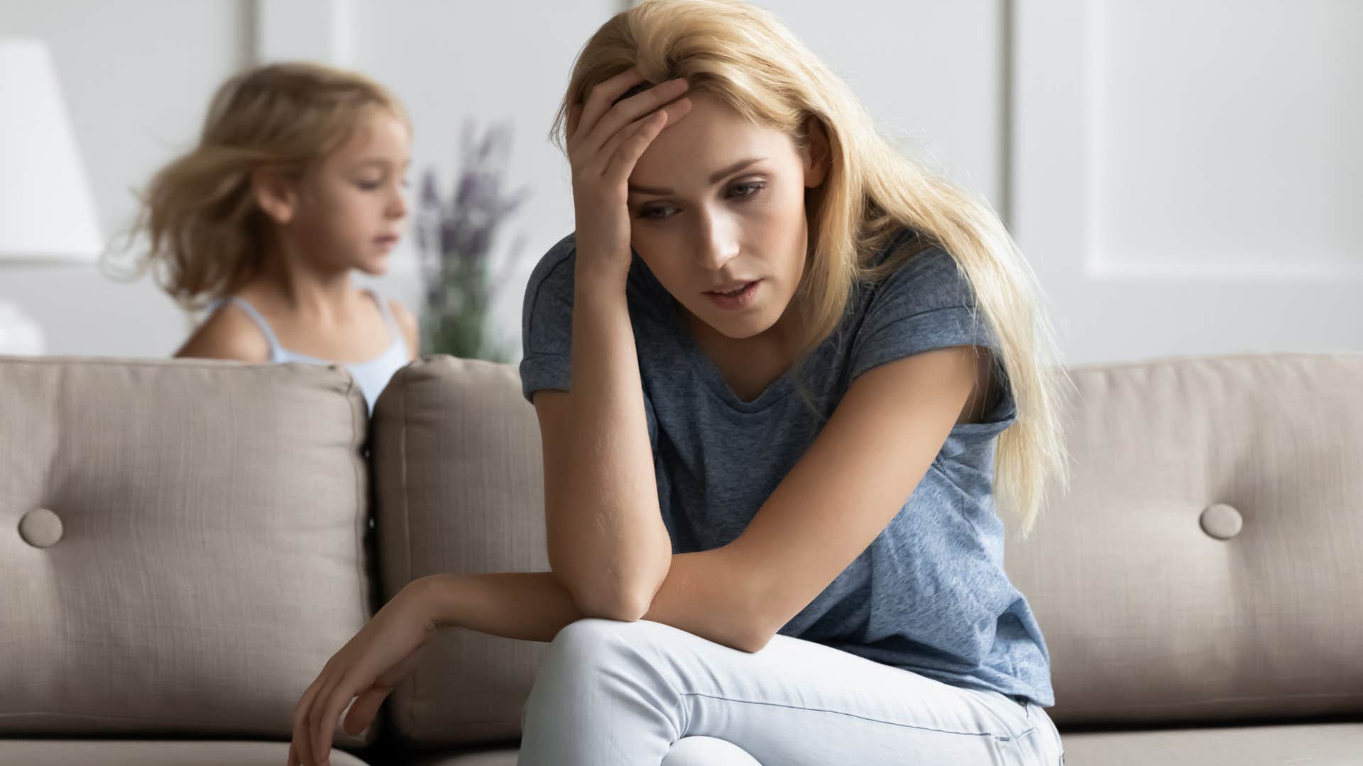 Woman looking tired and stressed while her kids runs around her.