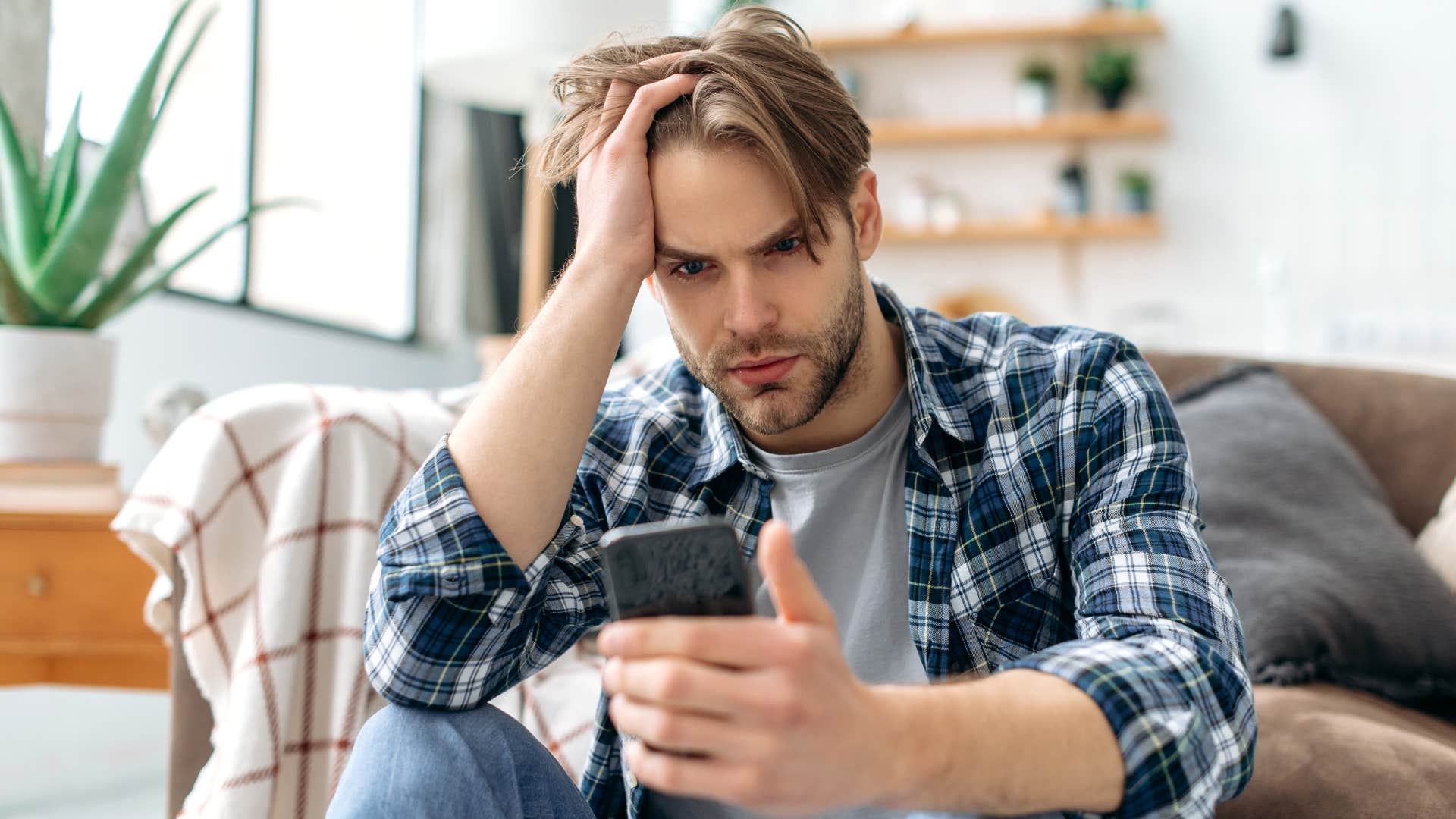 Man looking stressed staring at his phone.