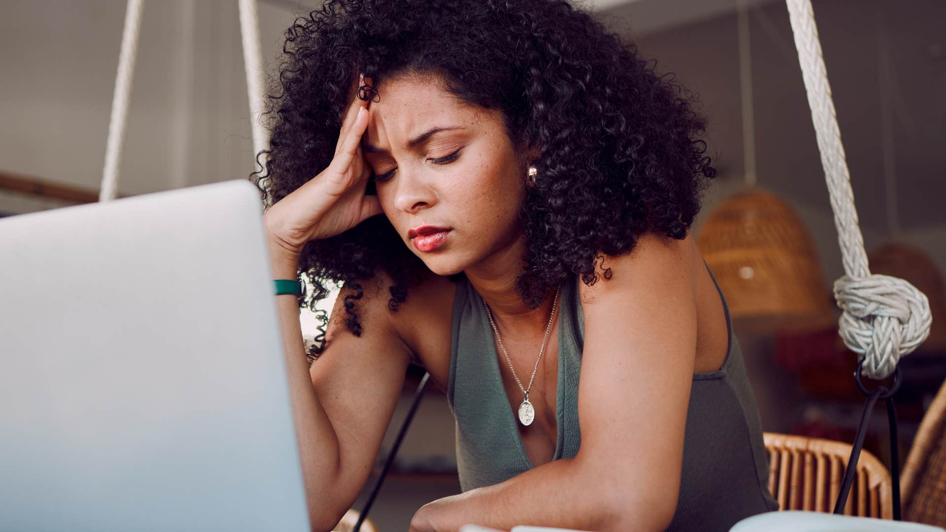 Woman looking tired staring at her laptop.