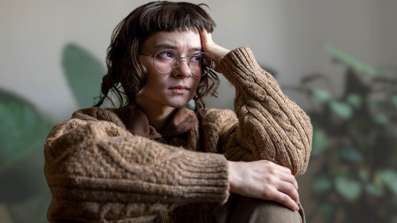 Stressed woman holding her head while sitting