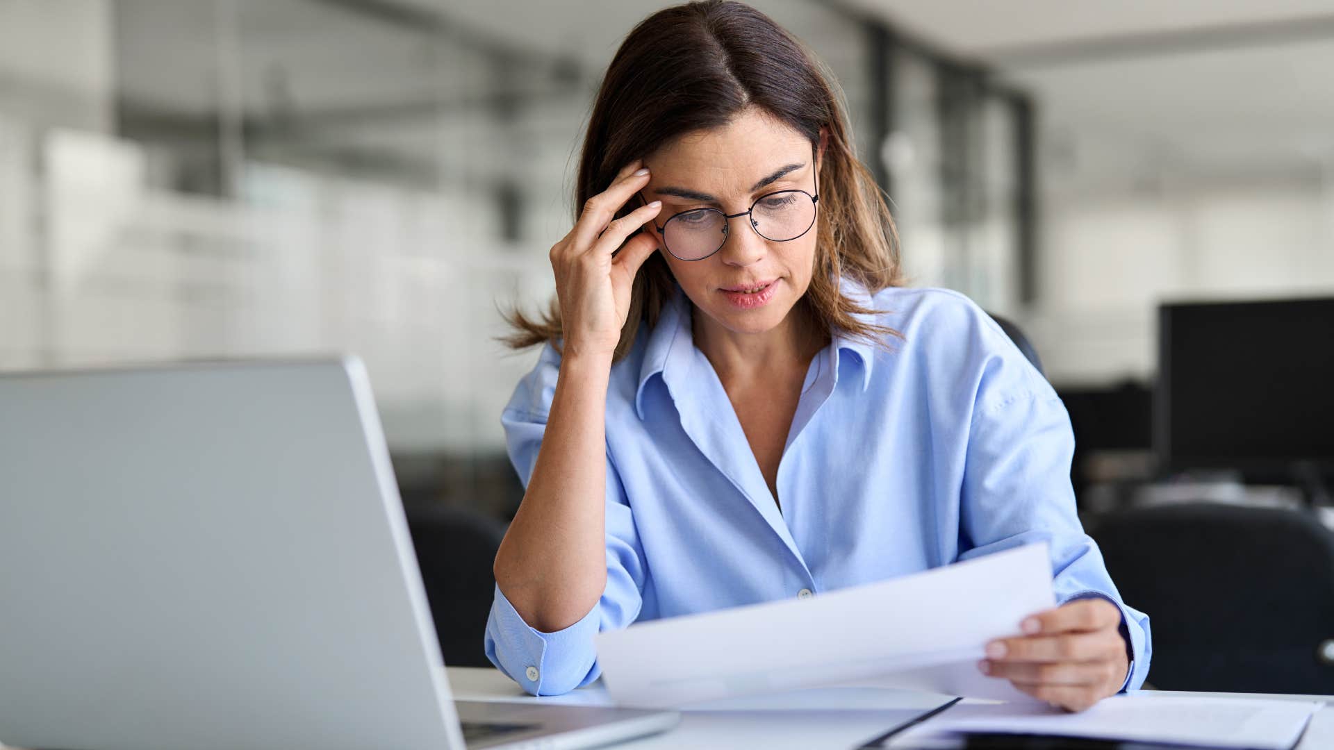 Woman looking confused while reading something at her desk