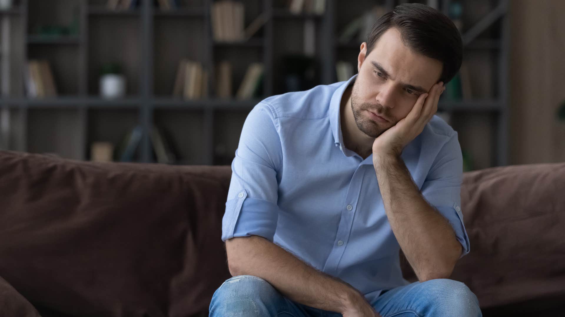 Upset man sitting on a couch.