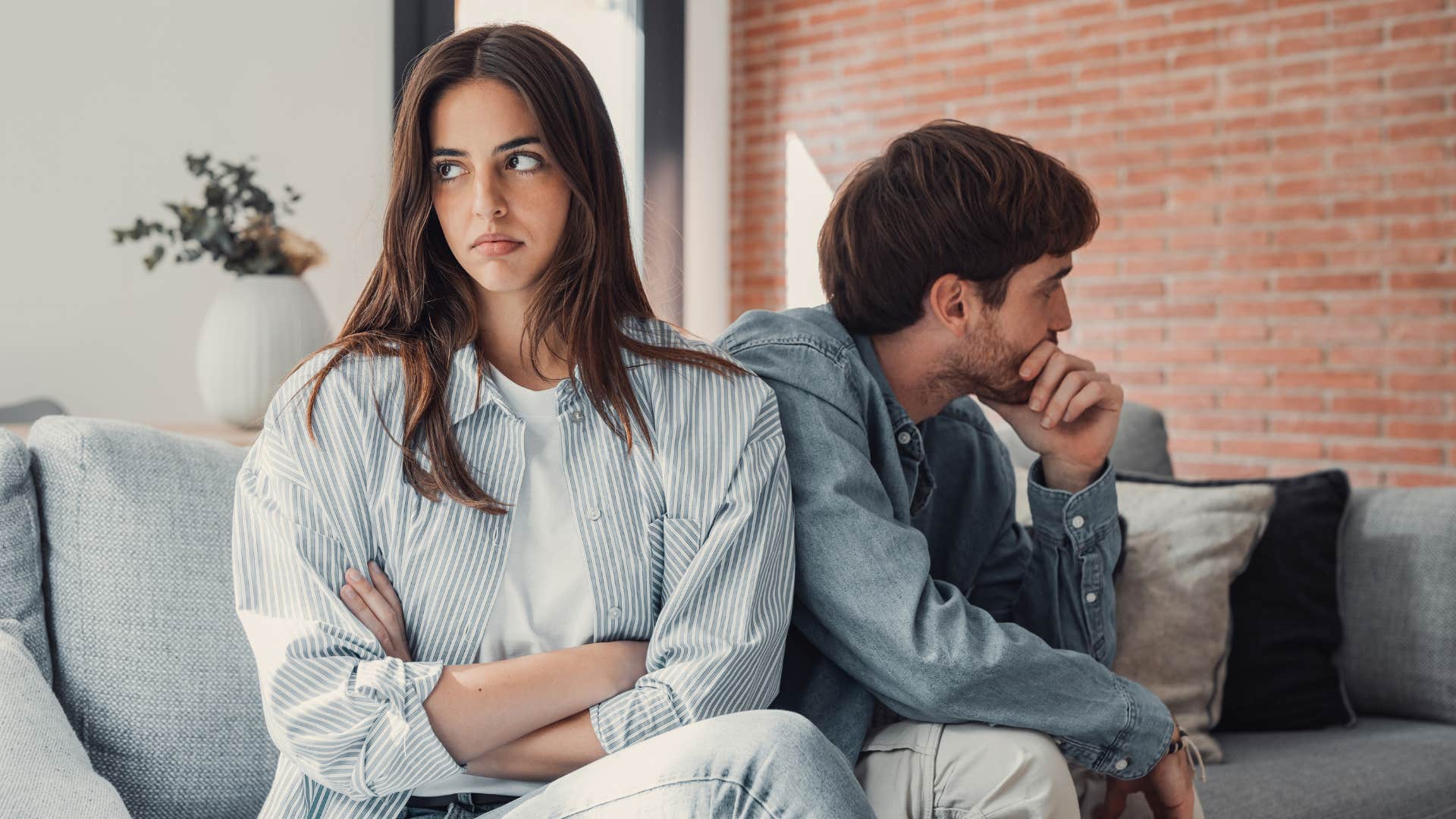 Couple looking away from each other with their arms crossed