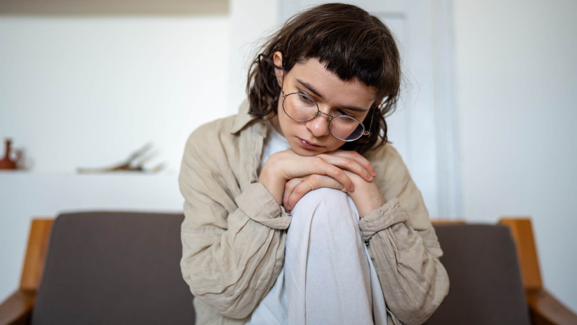 Woman looking upset with her head rested on her knee