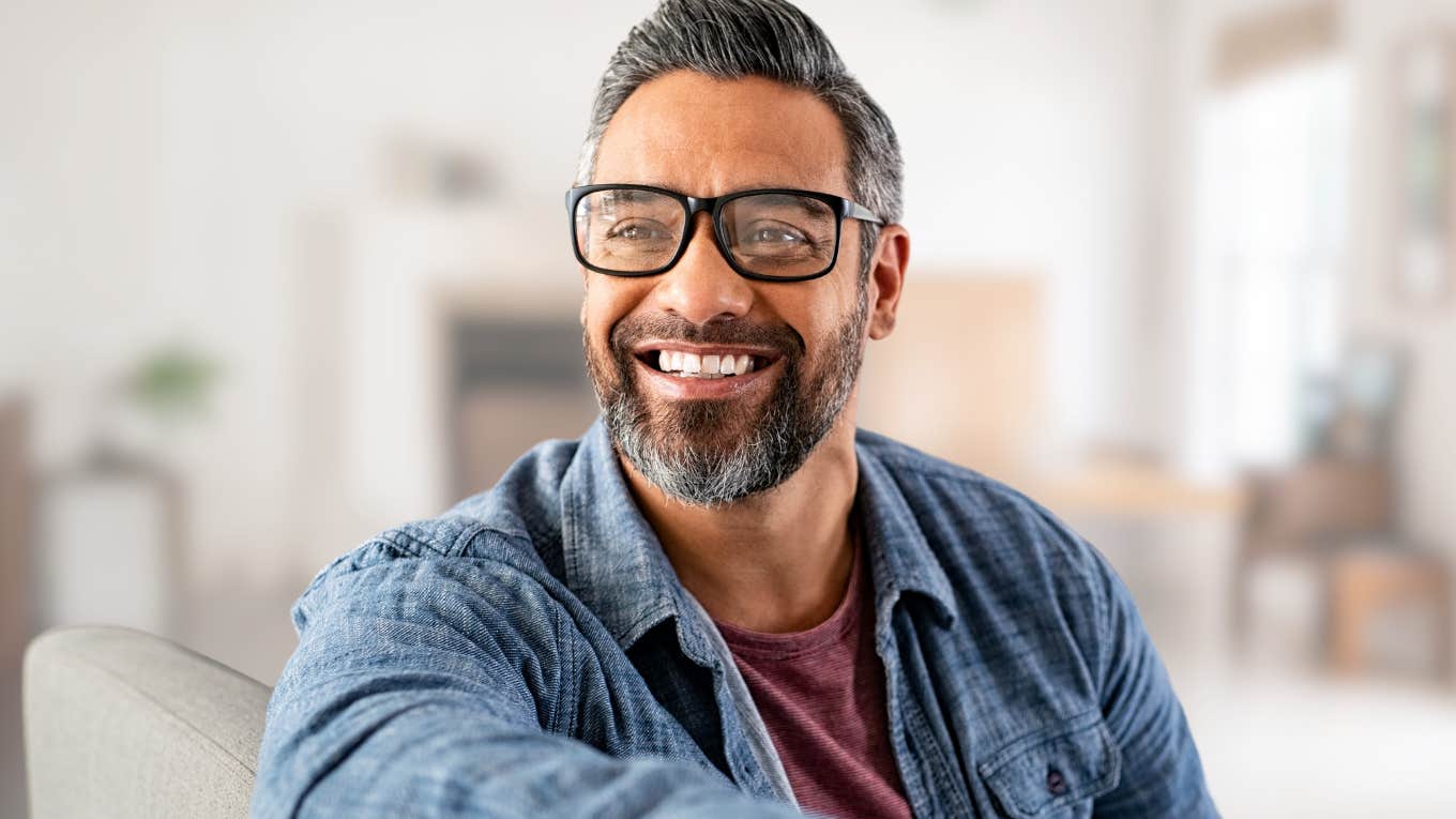 Self-aware man smiling at home