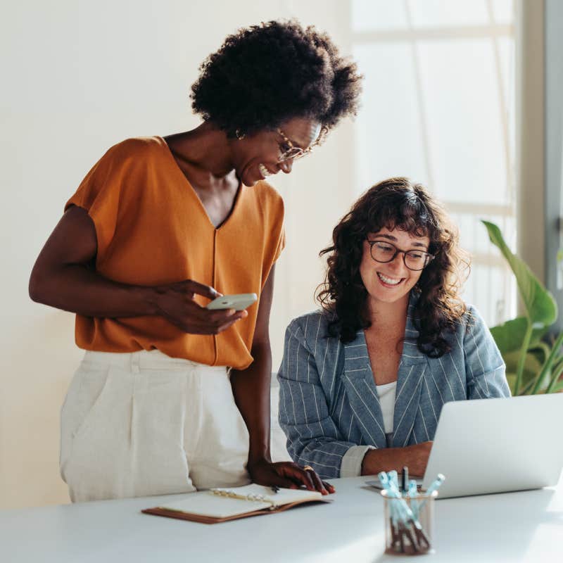 Happy professional women collaborating with enthusiasm in a modern office setting