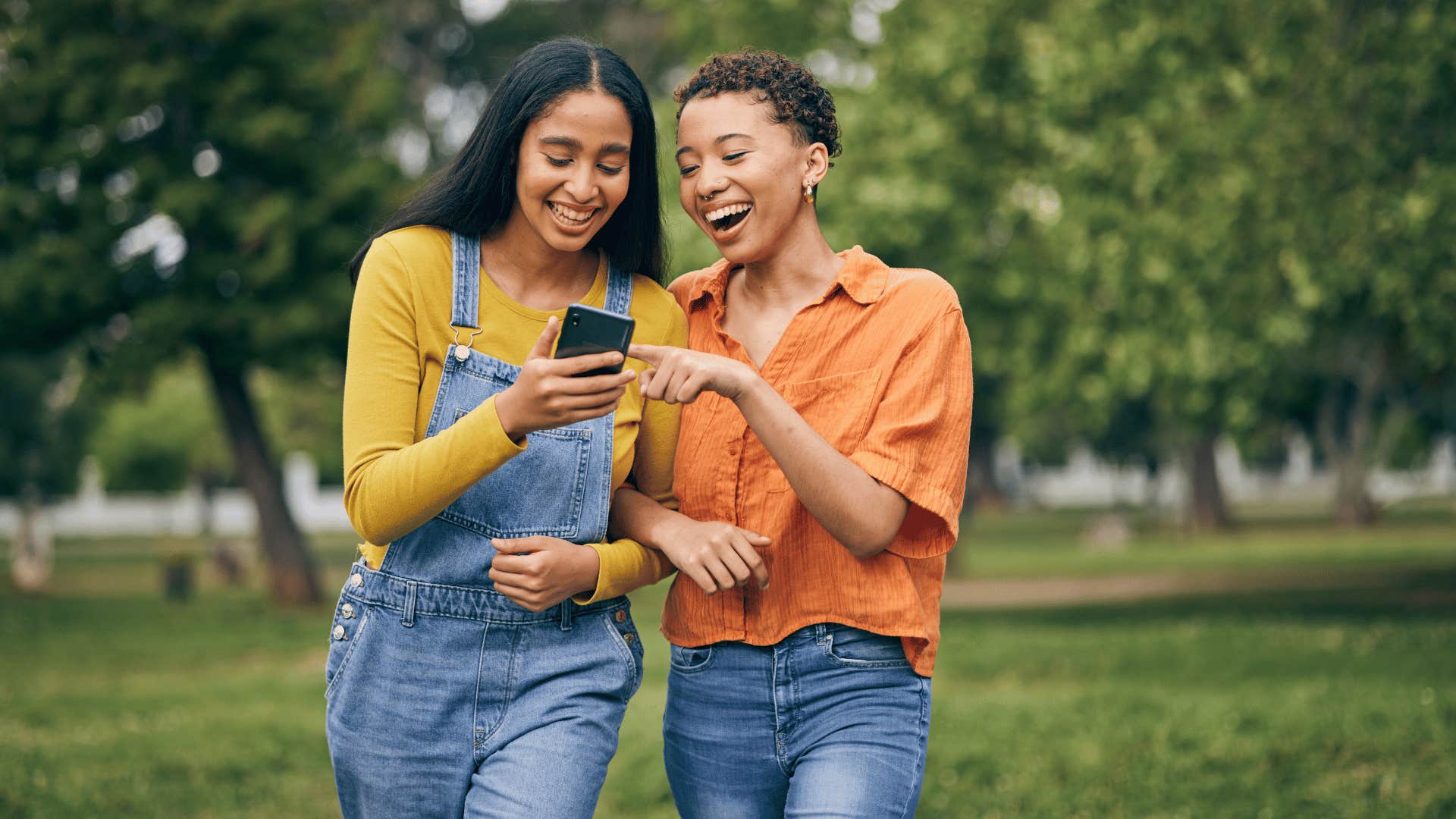 two women chatting while looking at phone together