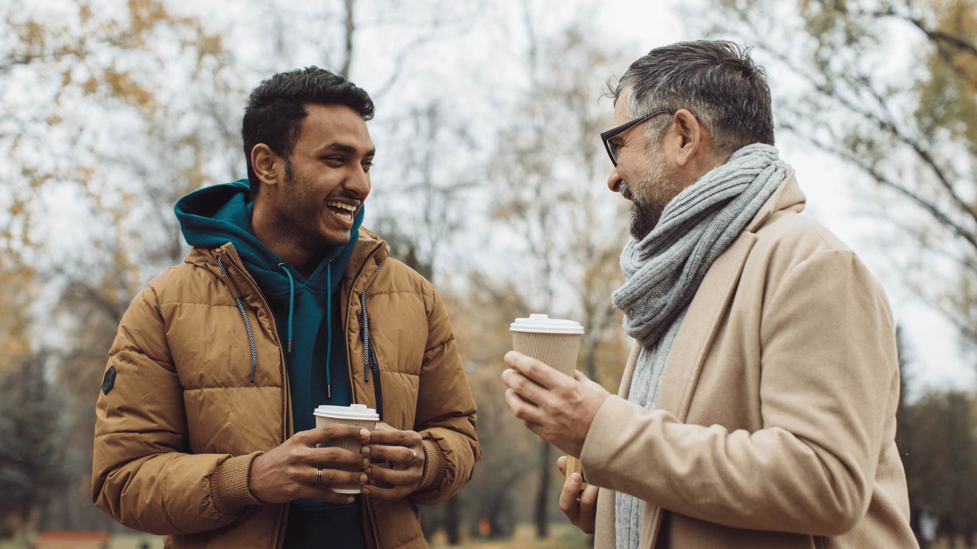 men holding coffee cups and talking