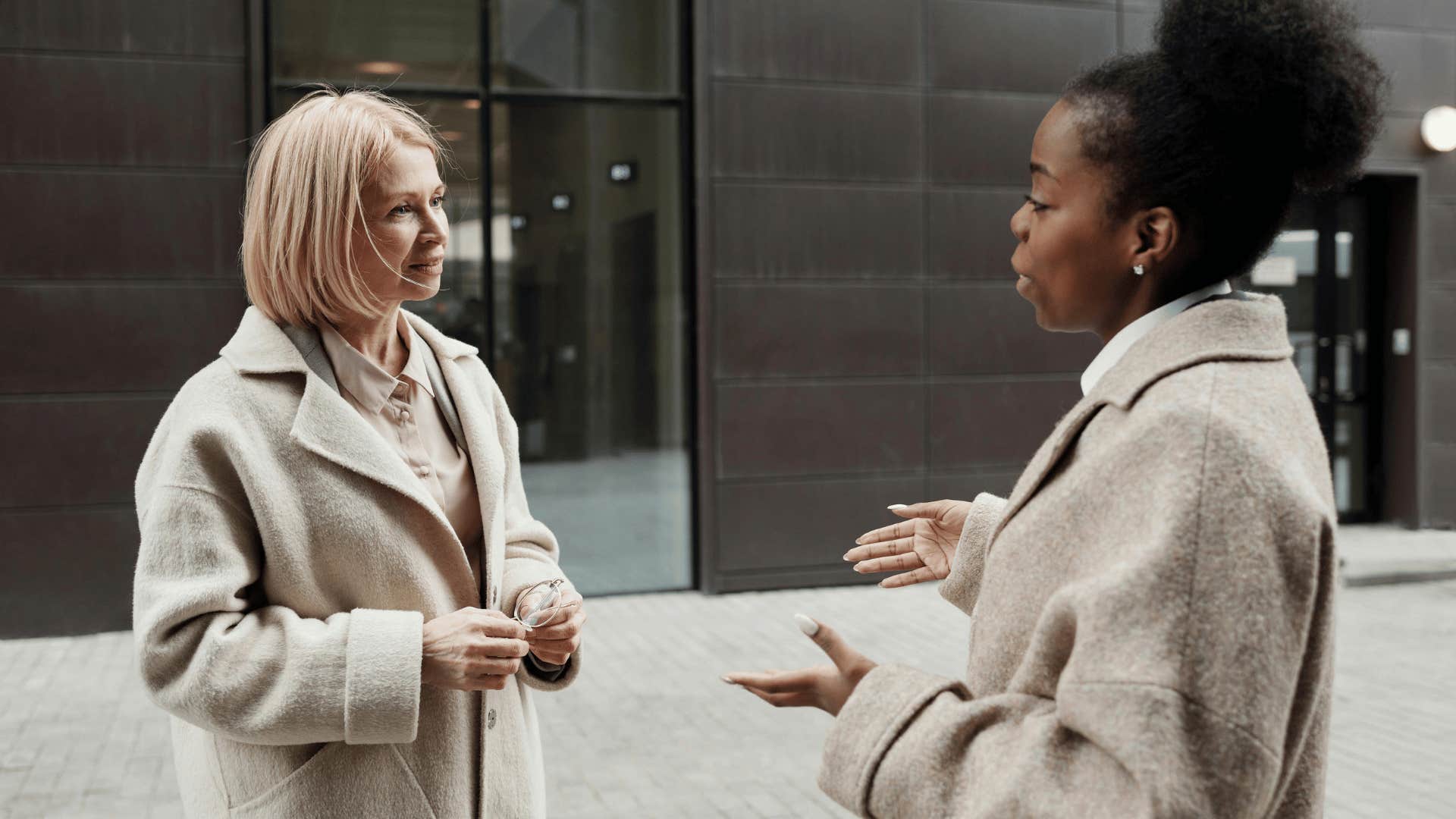 women in coats talking to each other