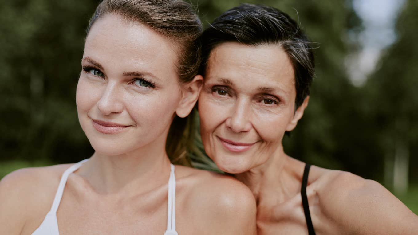 close up portrait of smiling adorable mother and daughter looking directly at camera