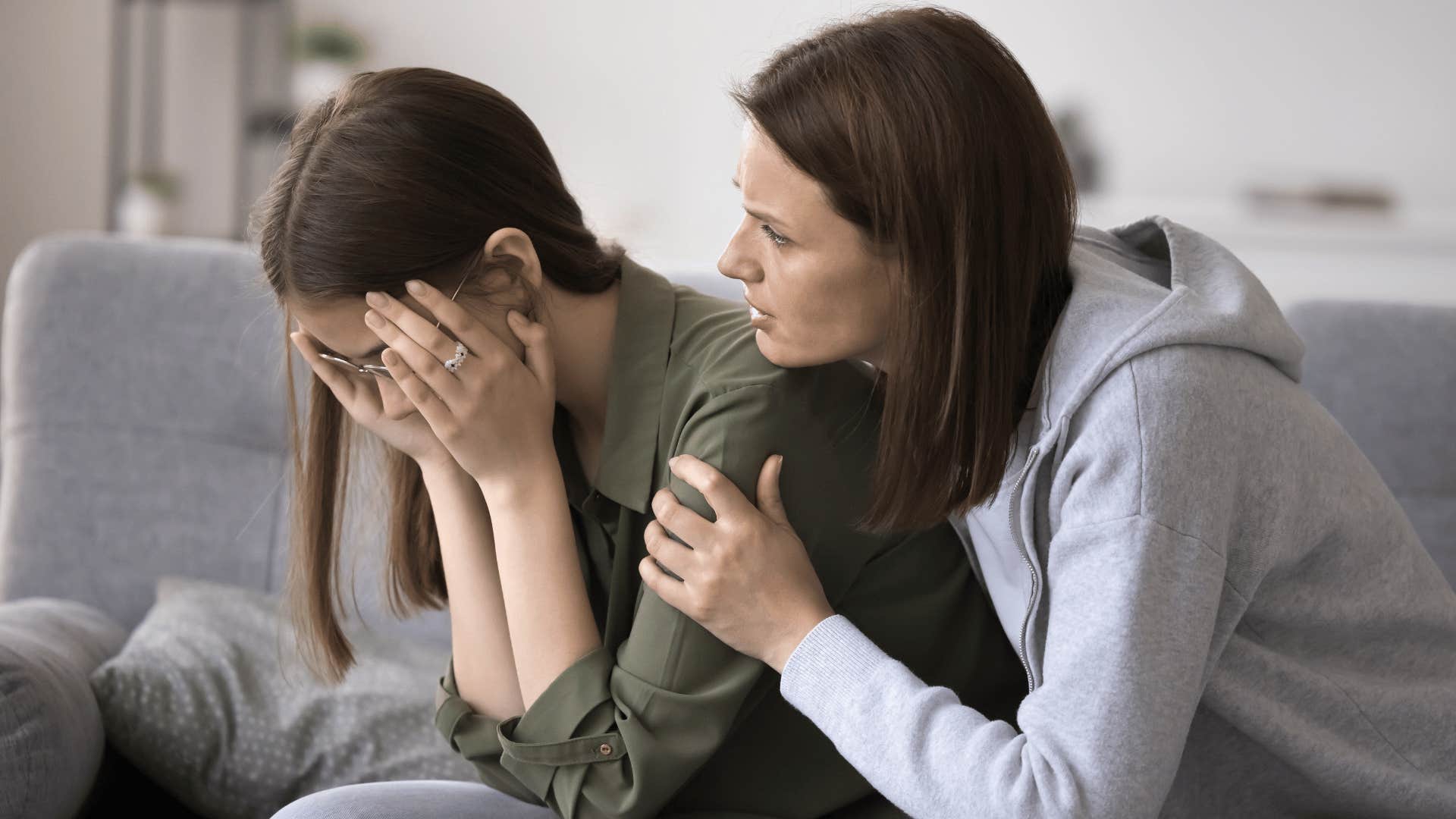 mother holding and comforting daughter while daughter is upset 