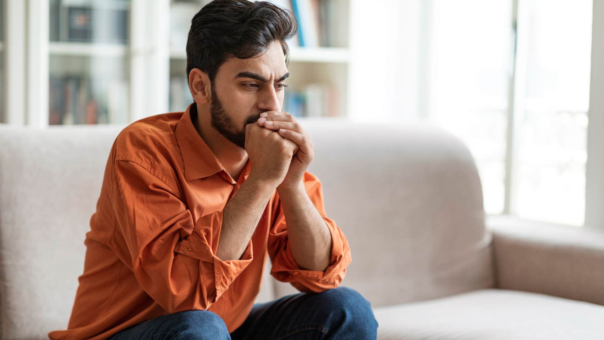 Man looking upset sitting on his couch