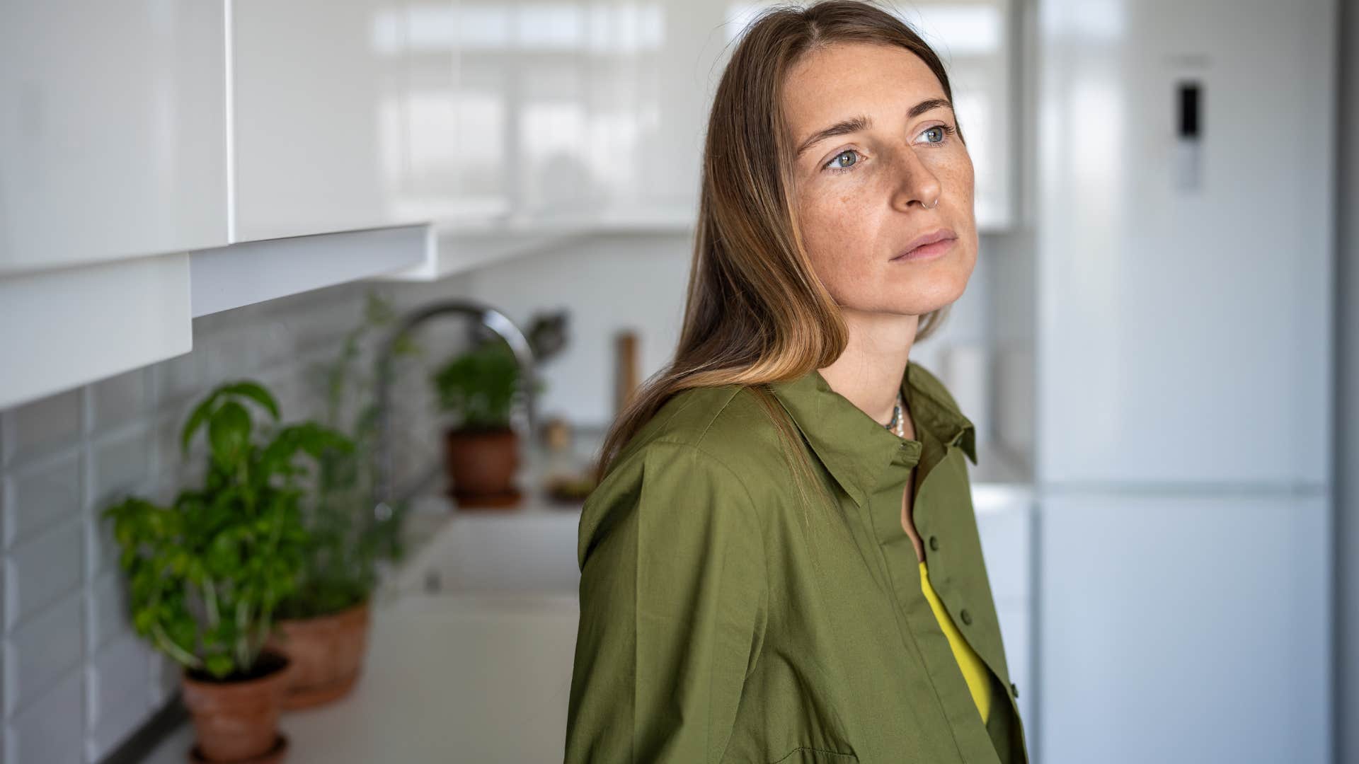 Woman looking solemn in her kitchen