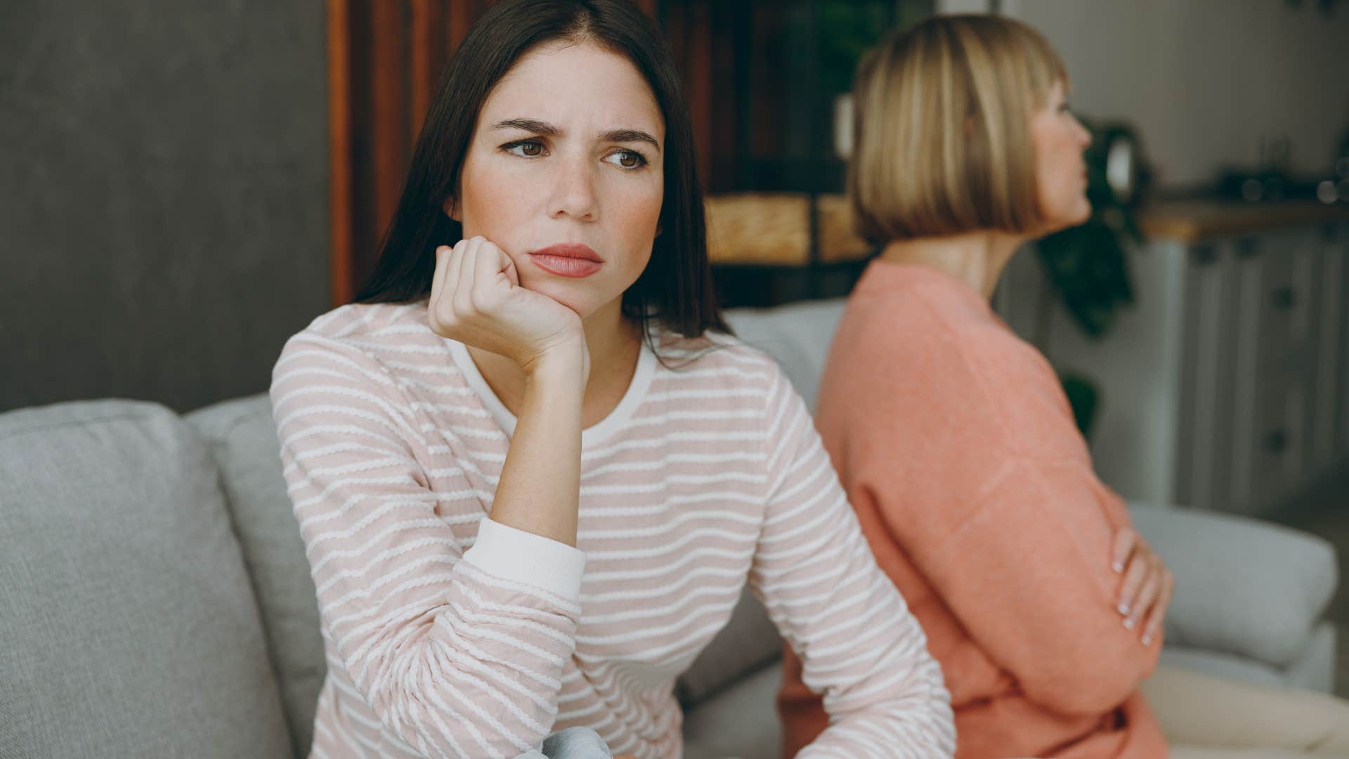 Woman looking annoyed sitting in front of her mother