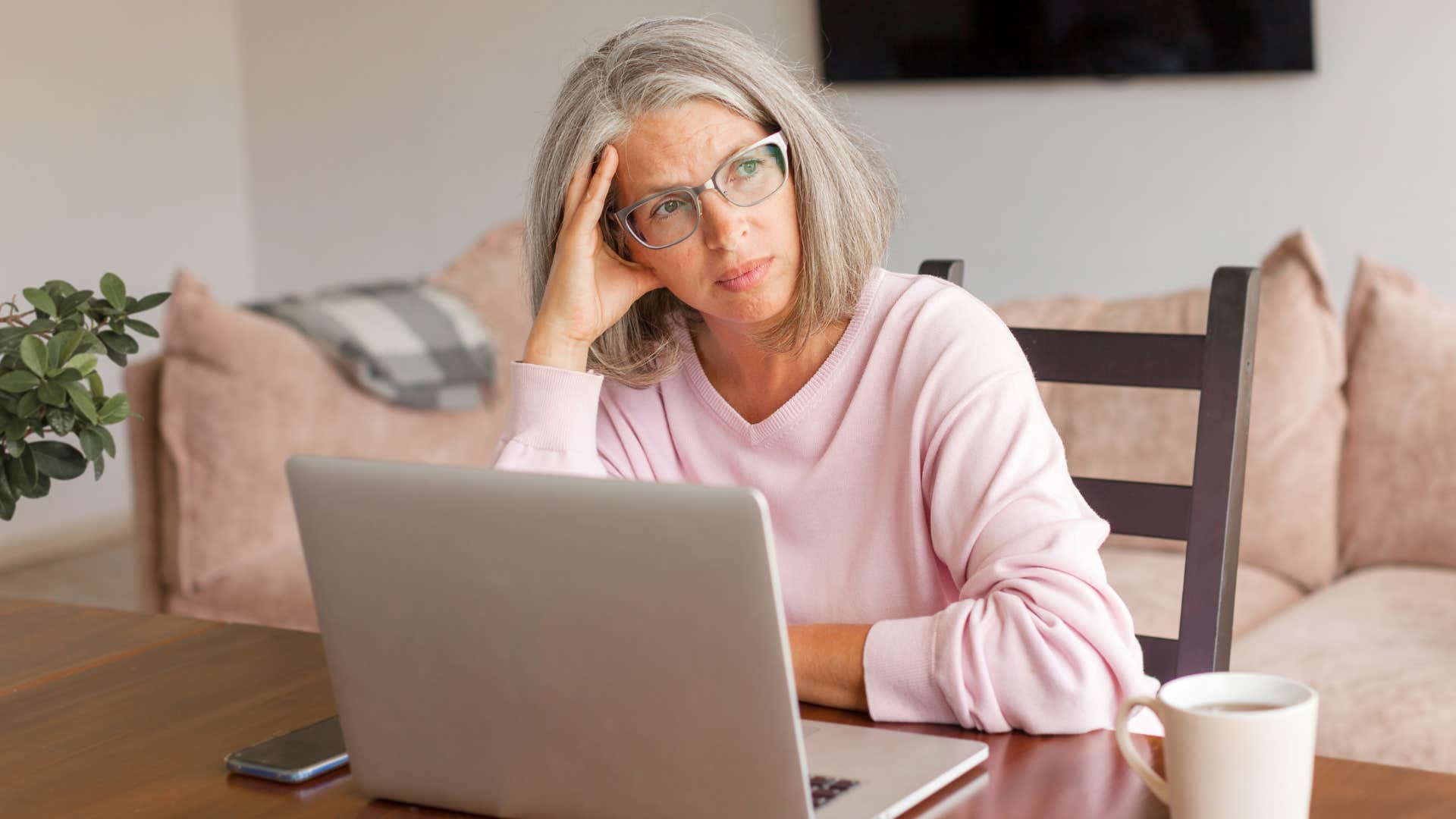 Woman looking upset sitting in front of her laptop