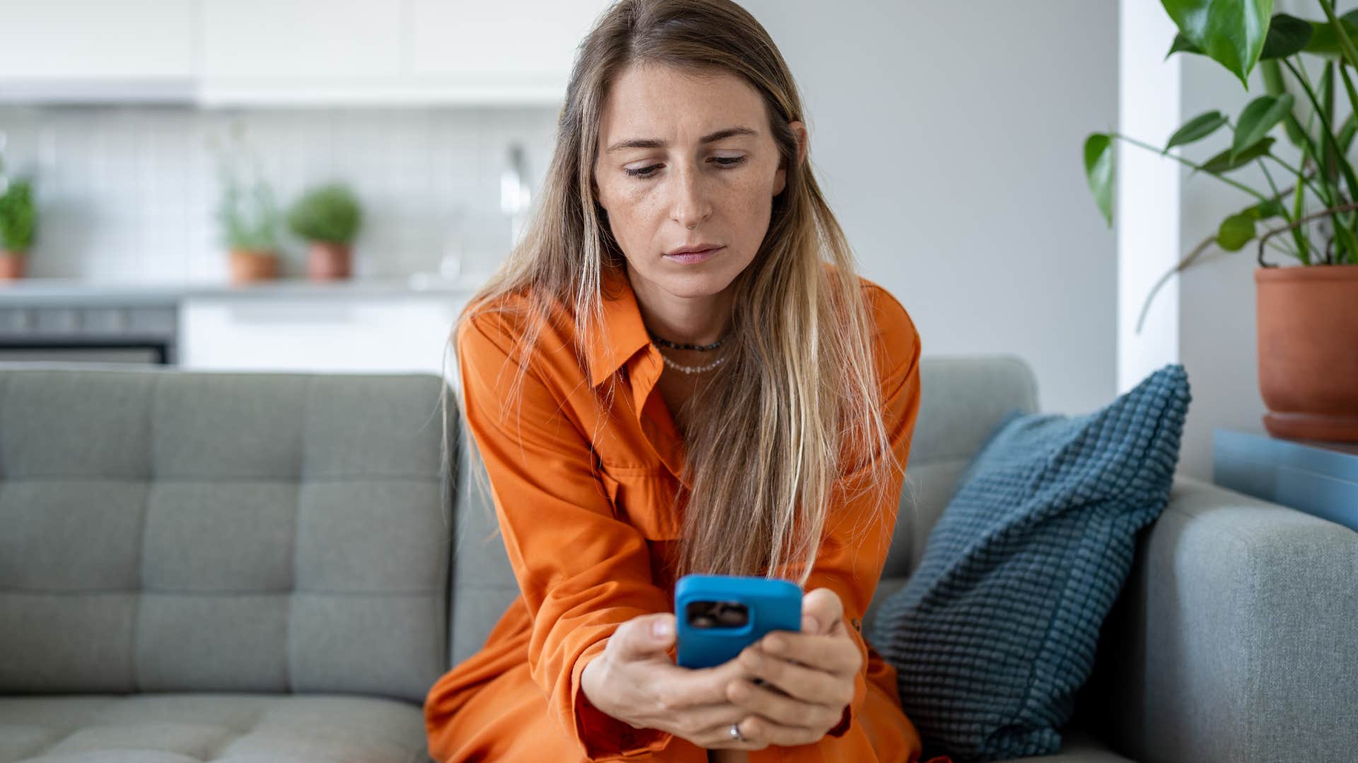 Sad woman scrolling on her phone.